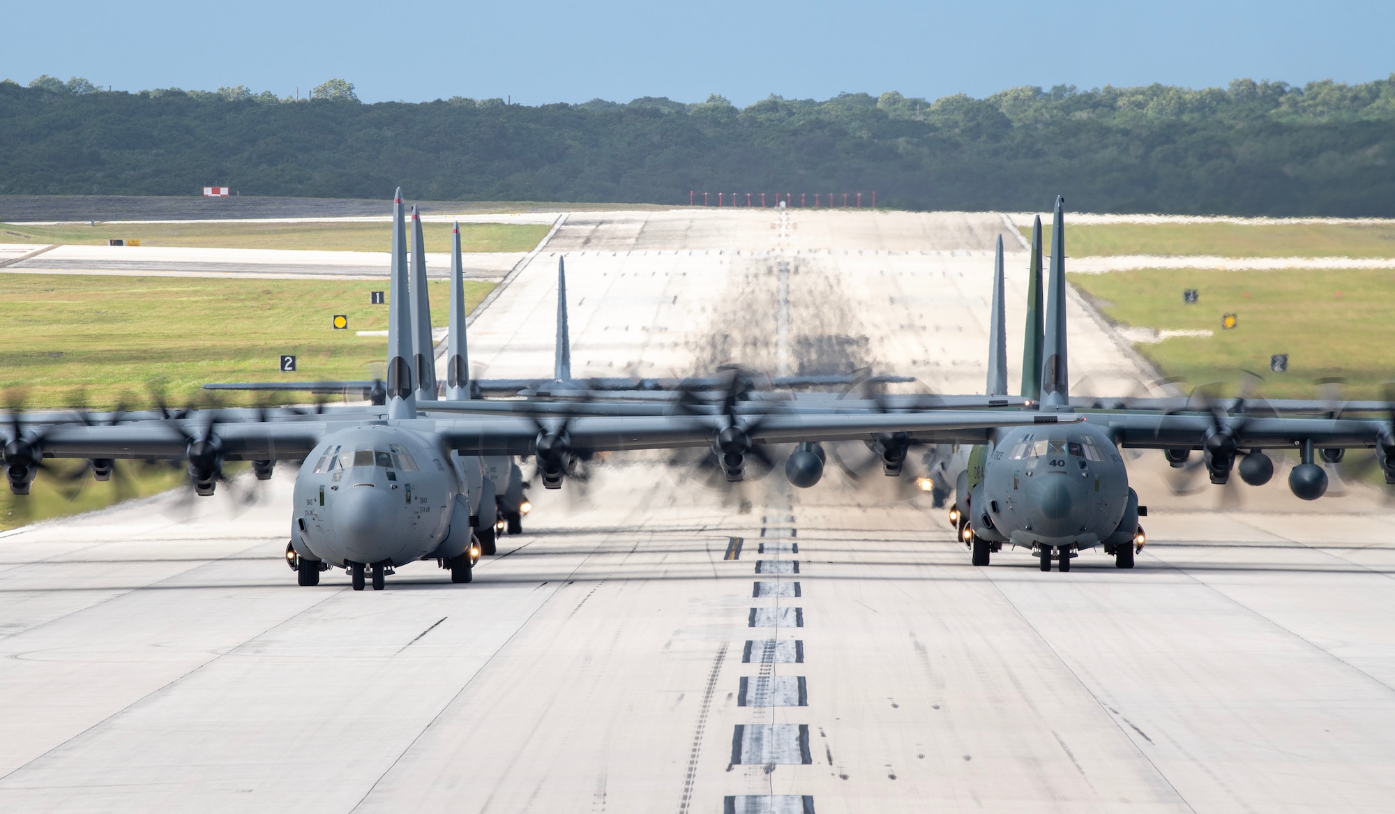 Seven C-130s conduct an elephant walk on a runway