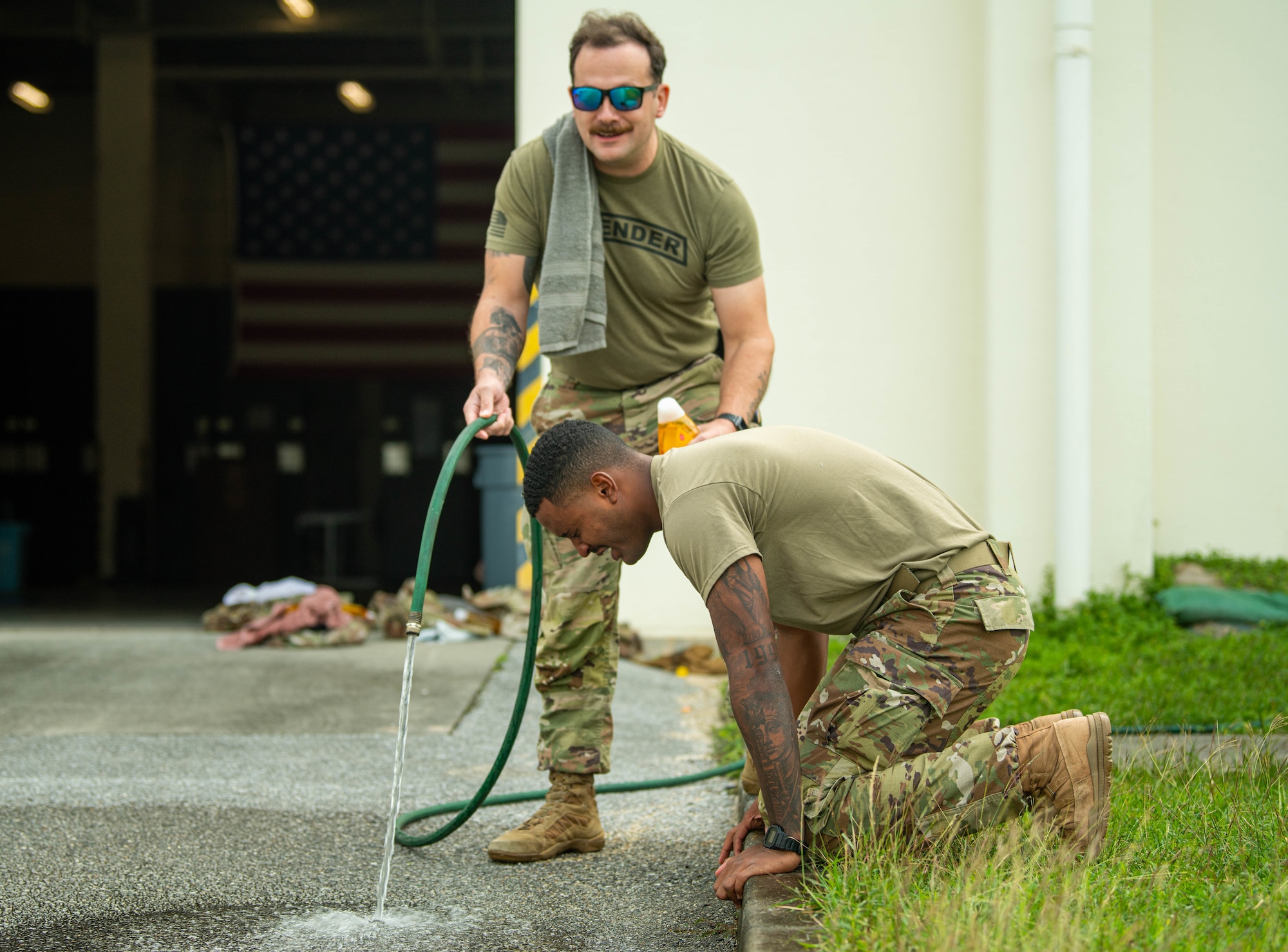 Defender rinses OC spray off after training.