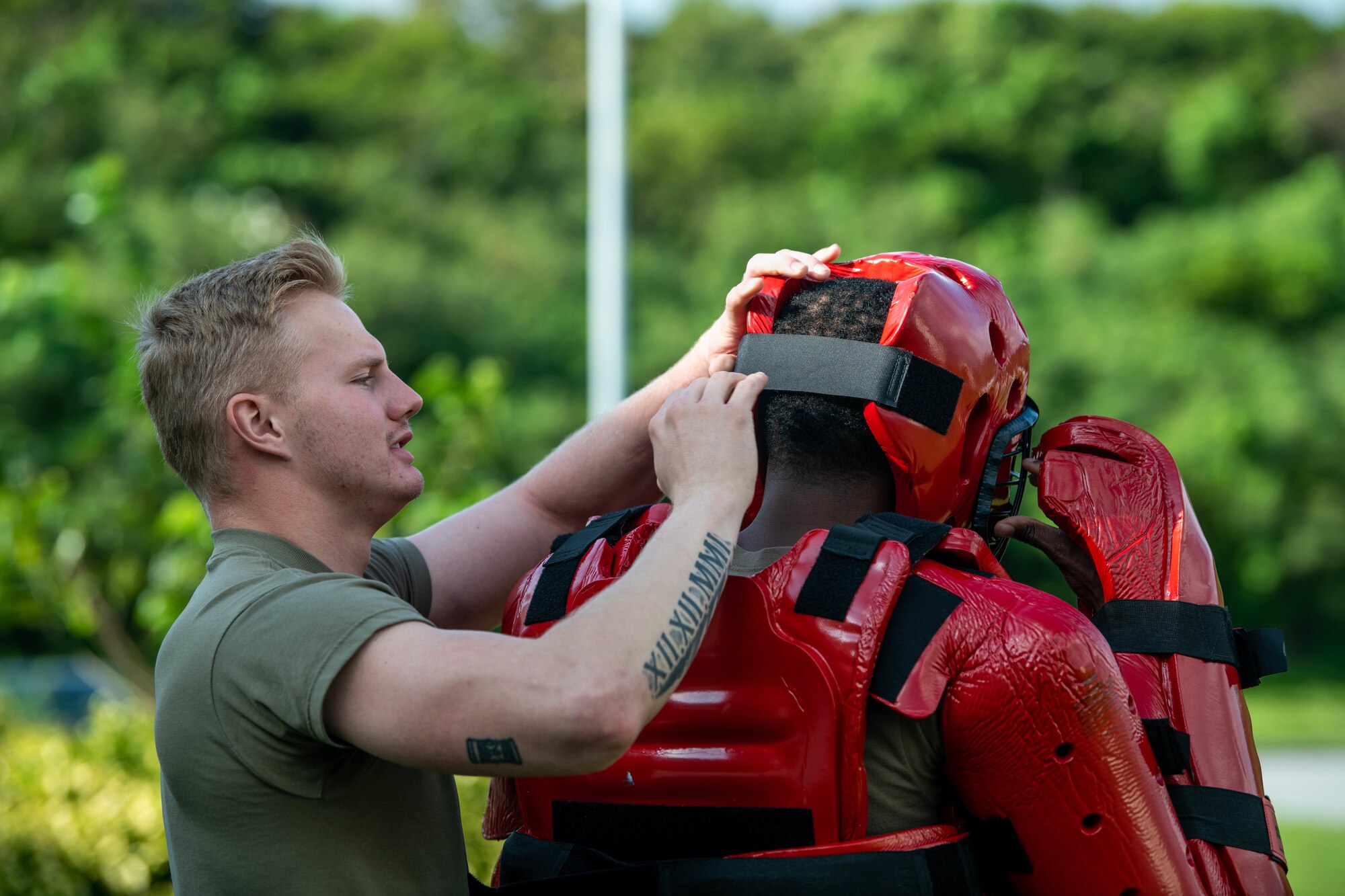 Defender fixes a strap on a Redman suit.