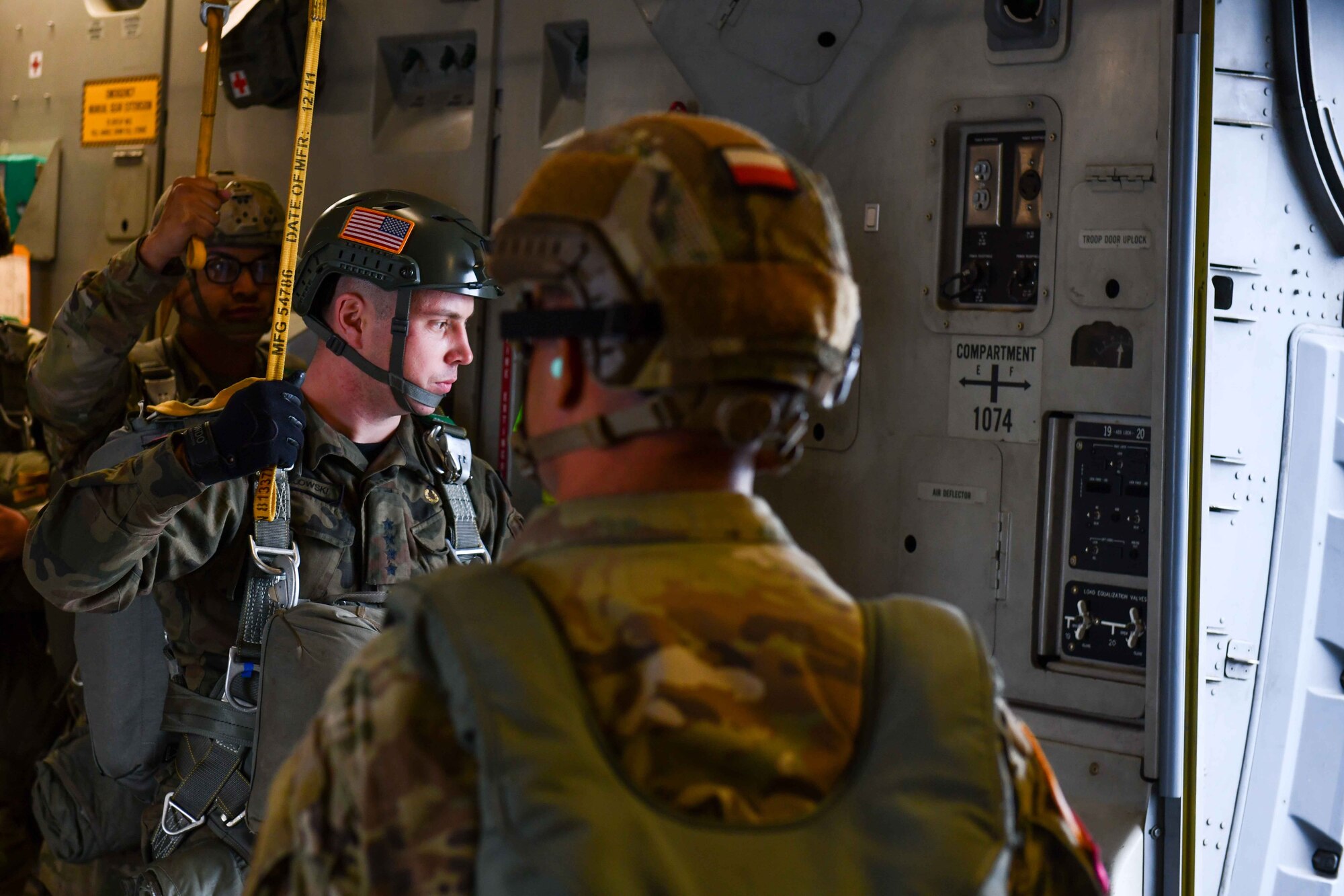 A jumper with the Polish Armed Forces waits for his turn to take a leap out of a C-17 Globemaster III from the 58th Airlift Squadron (AS) based out of Altus Air Force Base, Oklahoma, while flying over the Sicily Drop Zone near Fayetteville, North Carolina, Dec. 8, 2022. Military members from Poland joined the 58th AS aircrew on the first drop day of Operation Toy Drop. (U.S. Air Force photo by Airman 1st Class Kari Degraffenreed)