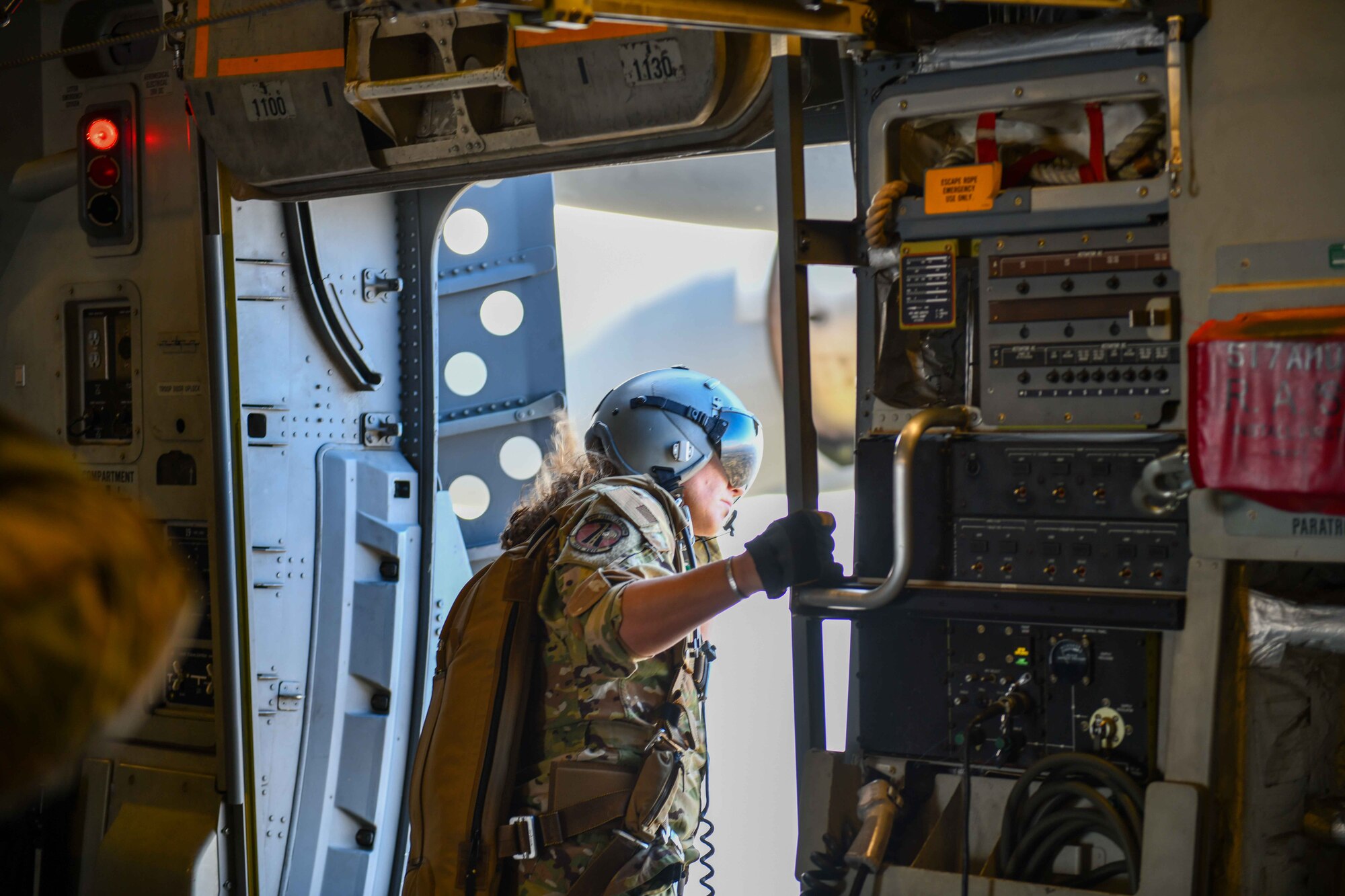 U.S. Air Force Reserves Master Sgt. Jayne Alexander, 730th Air Mobility Training Squadron loadmaster instructor, looks out the door of a C-17 Globemaster III as it flies closer to the Sicily Drop Zone near Fayetteville, North Carolina, Dec. 9, 2022. Loadmasters play an integral role during drop operations by communicating timing from pilots and jumpmasters, ensuring the safety of jumpers prior to the drop. (U.S. Air Force photo by Airman 1st Class Kari Degraffenreed)