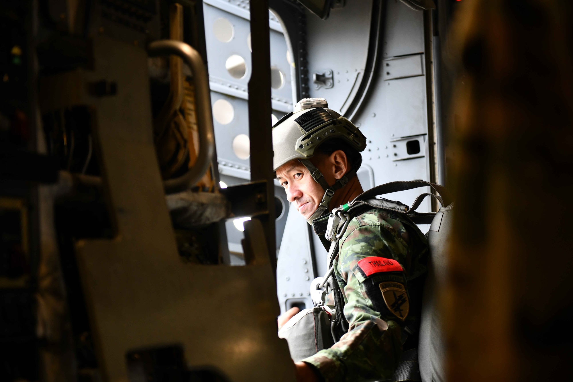 A jumpmaster from the Royal Thai Army waits at the door of a C-17 Globemaster III from the 58th Airlift Squadron based out of Altus Air Force Base, Oklahoma, as it flies closer to the Sicily Drop Zone near Fayetteville, North Carolina, Dec. 9, 2022. Operation Toy Drop was an opportunity for the U.S. military to work and train alongside partner nations including Thailand, Great Britain, Poland, France, Greece, Italy, Ireland, Romania, and the Ivory Coast. (U.S. Air Force photos by Airman 1st Class Kari Degraffenreed)