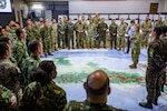 General addresses exercise participants while standing on a huge map of Central America.