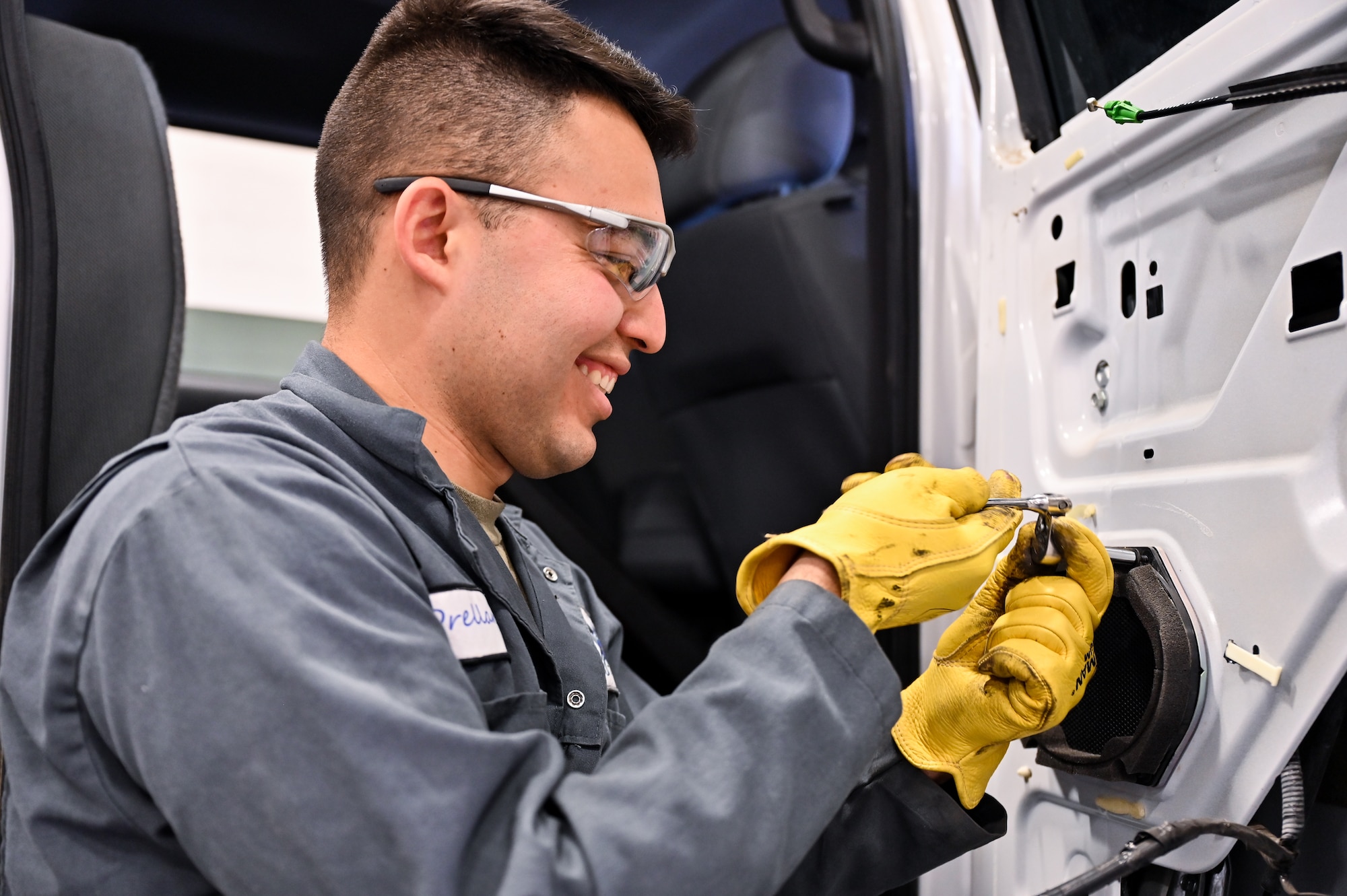Airman 1st Class Marcos Orellana, 90th Logistics Readiness Squadron vehicle maintenance technician, removes a bolt from a Ford truck's rear passenger door to replace the door after it was damaged on F.E. Warren Air Force Base, Wyoming, Nov. 29, 2022. Orellana is assigned to the body shop to learn basic skills he can use on future deployments. With more than 40 years of experience, the 90 LRS Monster Garage or body shop team is repairing the 90th Missile Wing fleet while supporting the Air Force Global Strike priority of people by finding ways to train the next generation of Airmen and find innovative solutions. (U.S. Air Force photo by Joseph Coslett Jr.)