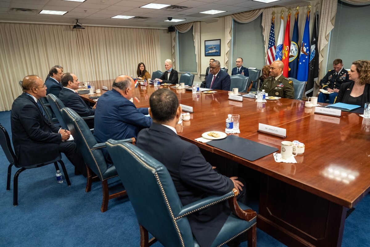 People sit at a large conference table.