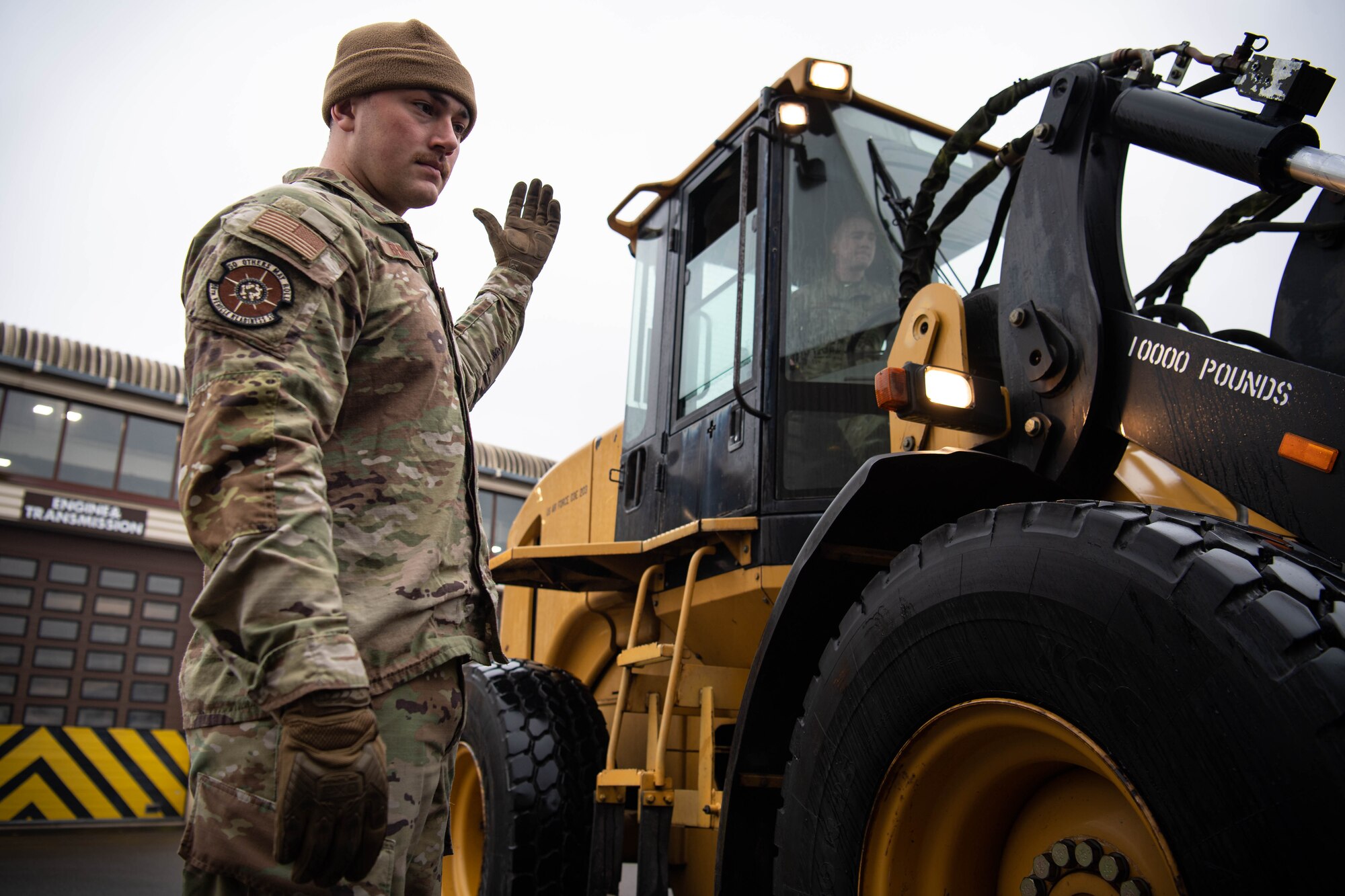 U.S. Air Force Airman 1st Class Tyler Benner, 86th Vehicle Readiness Squadron vehicle operator, guides an operator of a 10k all-terrain forklift at Ramstein Air Base, Germany, Nov. 30, 2022. A growth of an abscess on Benner’s liver put him in a life-threatening situation that left him in the hospital for months, until finally the correct treatment was found. Since then he has returned to his personal passions and goals within his Air Force career. (U.S. Air Force photo by Airman 1st Class Jared Lovett)