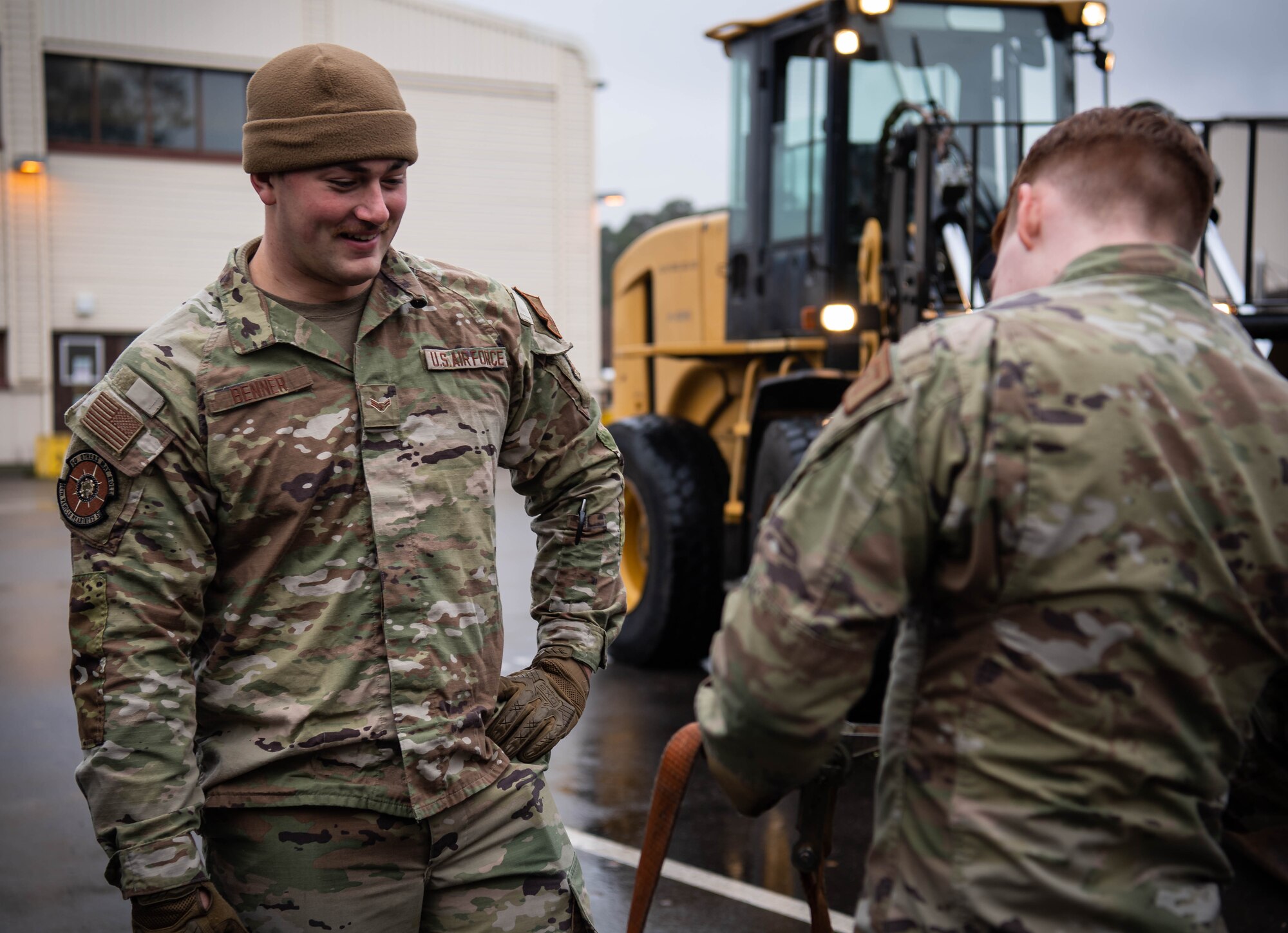 U.S. Air Force Airman 1st Class Tyler Benner, left, 86th Vehicle Readiness Squadron vehicle operator and Airman 1st Class Jeremy Evans, right, 86th VRS ground transportation operator, secure a shipping container at Ramstein Air Base, Germany, Nov. 30, 2022. Benner says he takes nothing for granted anymore, after surviving a rare medical condition that left him in the hospital for months.  Aggregatibacter aphrophilus, a common bacteria residing in the mouth, caused his blood to become septic and resulted in the growth of a baseball-sized abscess in his liver. (U.S. Air Force photo by Airman 1st Class Jared Lovett)