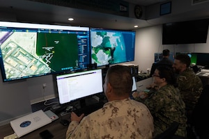 Royal Canadian Navy Lt. Cmdr. Brian MacMillan, left, Intelligence Specialist 1st Class Samantha Jordan, center, and UK Royal Navy Lt. Andrew Burns, participate in Digital Horizon 2022 in the Task Force 59 Robotics Operations Center, Nov. 28. The three-week unmanned and artificial intelligence integration event involves employing new platforms in the region for the first time.