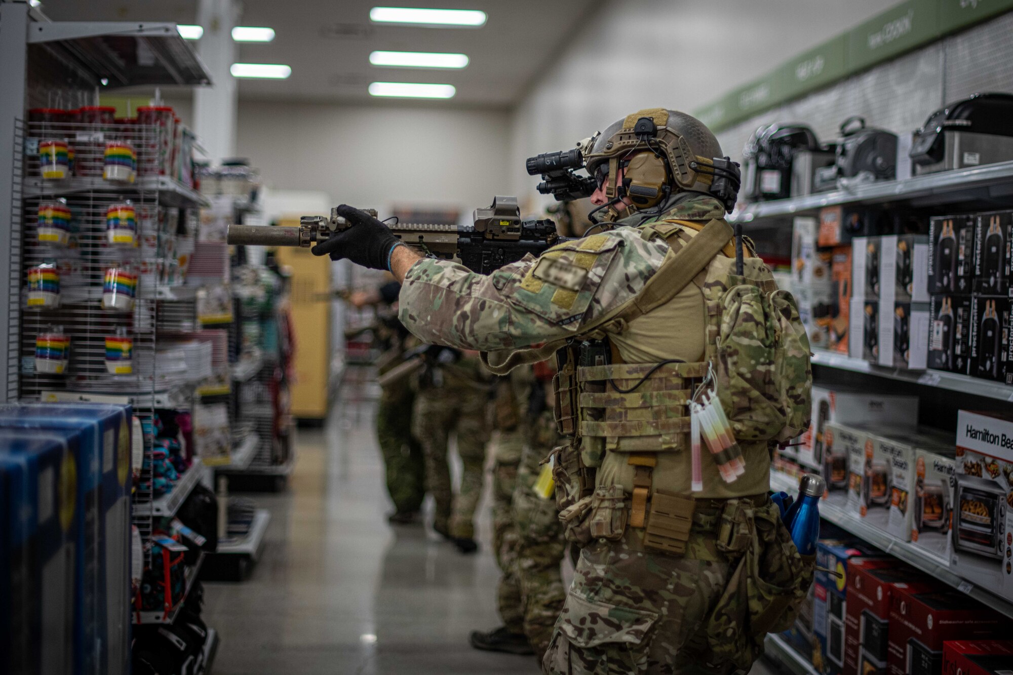 Soldiers check aisles during an exercise.