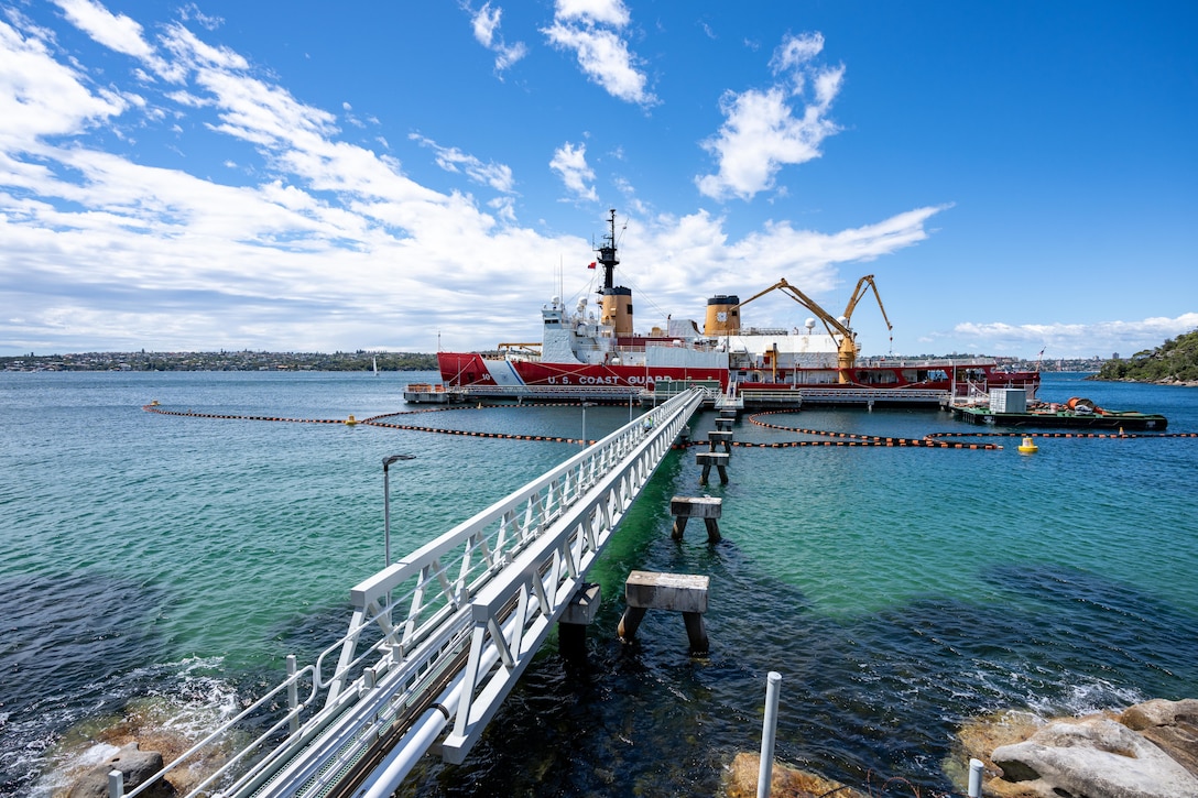 A Coast Guard ship is refueled in a harbor.