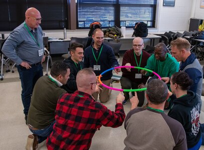 Under the watchful eye of Israeli reserve Lt. Col. Opher Ben Gershon, Emergency Readiness and Management Expert, members of the Illinois National Guard develop teamwork skills by lowering a hula hoop to the floor with each participant keeping the hoop on their fingernail.