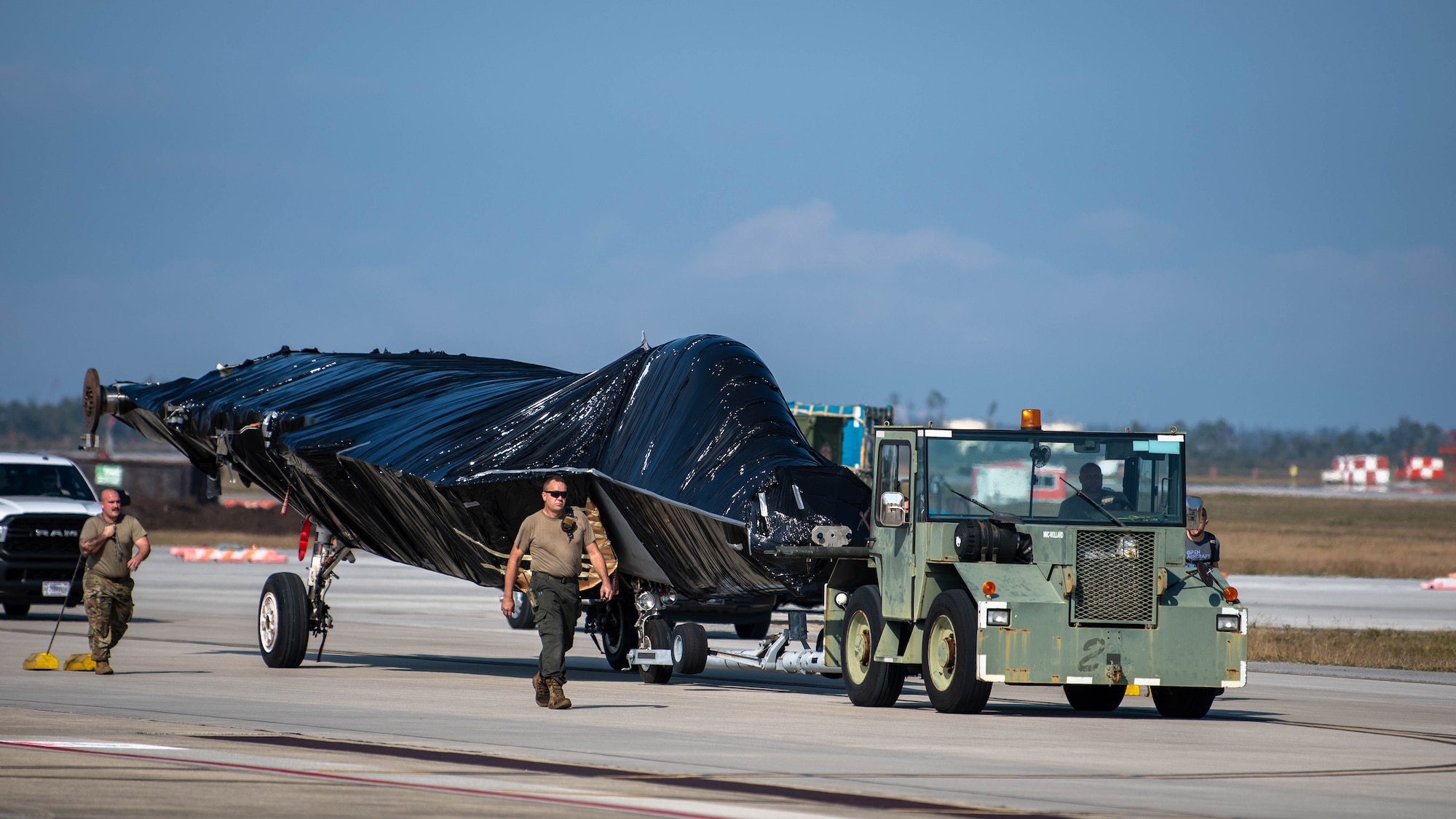 Uniformed members escort a wrapped jet.