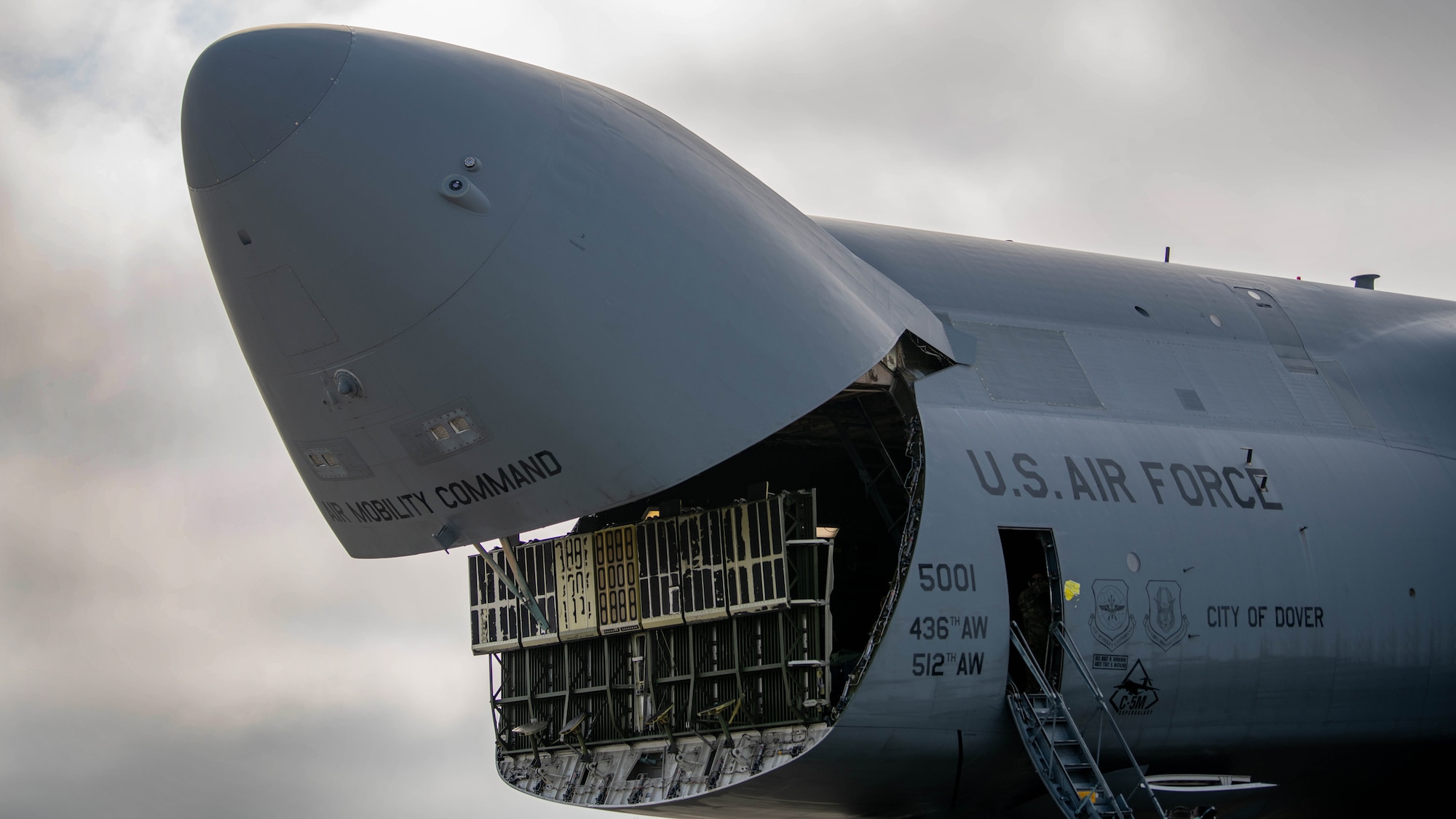 A large aircrafts front storage door opens.