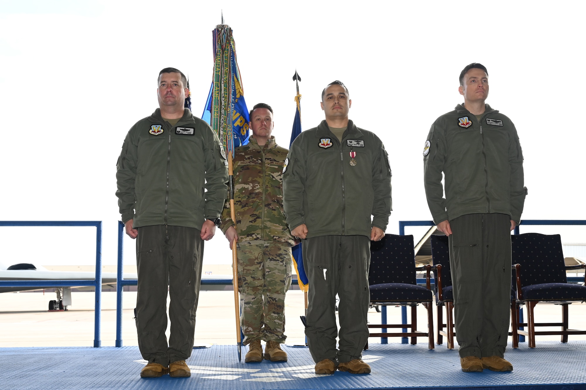 Col. Daniel Lehoski, United States Air Force Weapons School Commandant (left), Lt. Col. Marcus Antonini, previous 325th Weapons Squadron, 57th Wing (center), and Lt. Col. Alexander Reich, 325th Weapons Squadron, 57th Wing (right), stand at attention at Whiteman Air Force Base, Missouri, December 14, 2022. Change of commands are a military tradition of passing command from one commanding officer to another. (U.S. Air Force photo by Airman 1st Class Joseph Garcia)