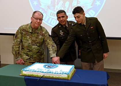 From left, the NHANG's oldest guardsman, Chief Master Sgt. Alfred Orsini, NH Adjutant Gen. David Mikolaities, and the NHARNG's youngest guardsman, Pvt. Waleed Shahin, cut a cake with a ceremonial sword during the Guard's 386th birthday celebration and annual awards ceremony Dec. 13, 2022, at the Edward Cross Training Complex in Pembroke.