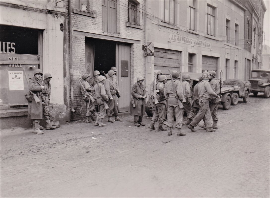 Infantrymen of the 28th Infantry Division’s 110th Infantry Regiment gather in Bastogne, Belgium, to regroup after being cut away from their regiment by the Germans in the enemy drive in this area on Dec. 19, 1944. (U.S. Army Signal Corps photo)