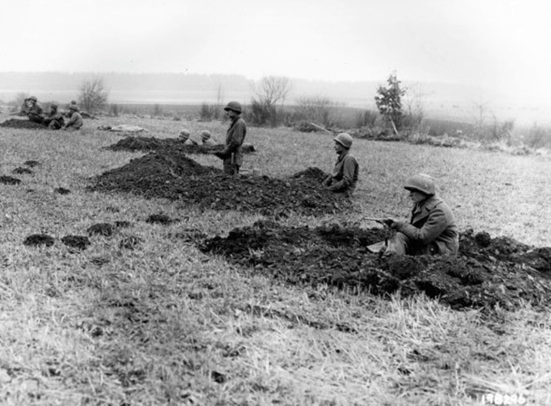 Soldiers of the 28th Infantry Division who had been regrouped into security platoons for defense of Bastogne, Belgium, man fighting positions on Dec. 20, 1944. Some of these Soldiers lost their weapons during the German advance in this area. (U.S. Army Signal Corps photo by Tech 5 Wesley B. Carolan)