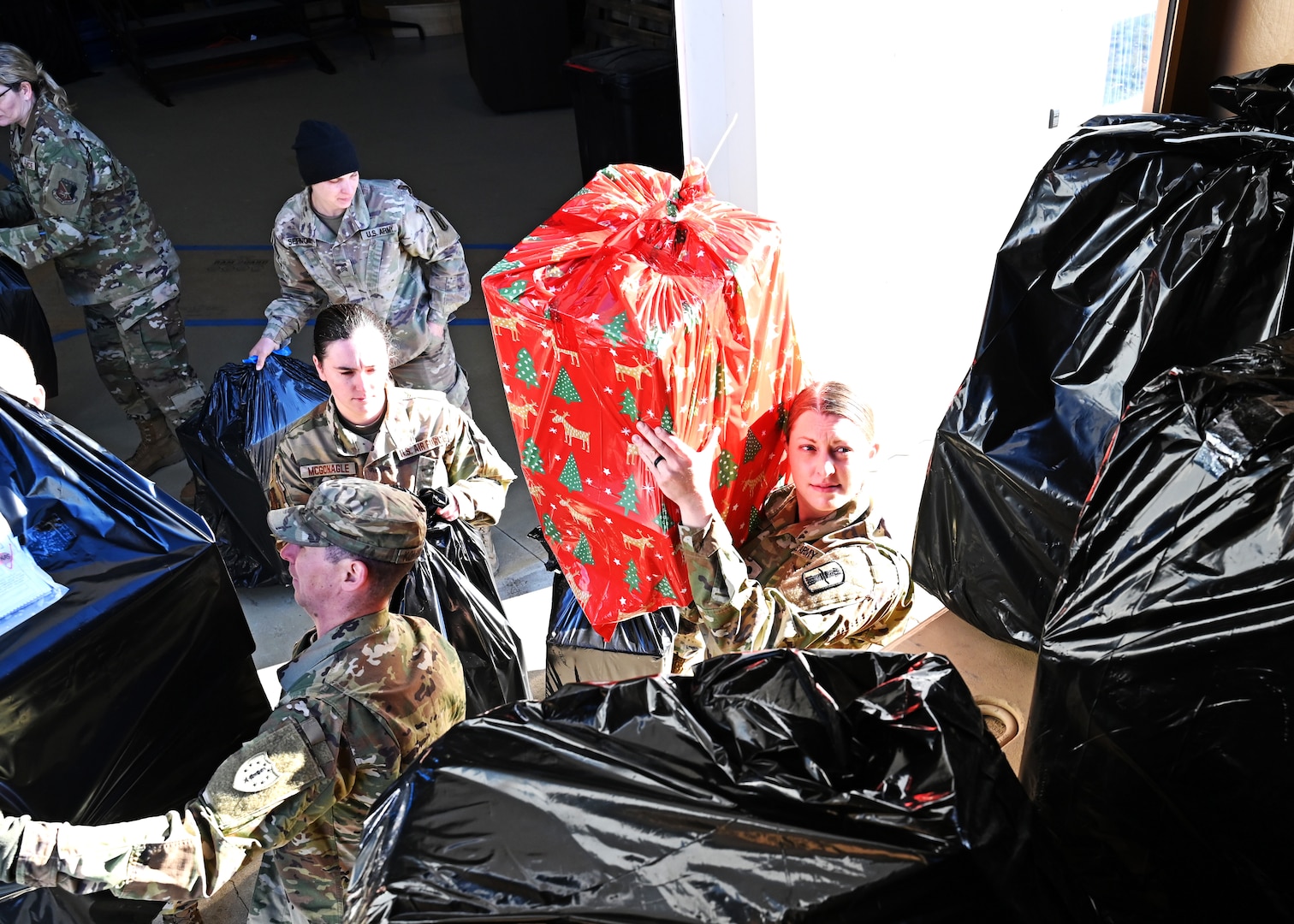 Spc. Kelly Boyer of the 603rd Public Affairs Detachment, NHARNG, loads a donated Christmas gift onto a delivery truck Dec. 13, 2022, at the state military reservation in Concord.