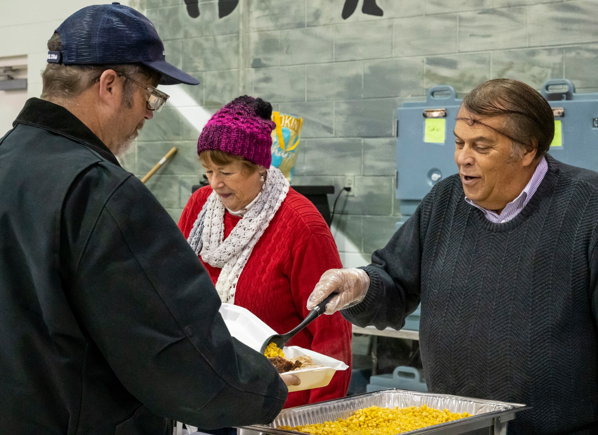 Robin Christiansen, right, City of Dover mayor, serves Team Dover members as they move through the serving line during Operation Feed the Troops on Dover Air Force Base, Delaware, Dec. 14, 2022. OFT volunteers served a traditional holiday meal to members of Team Dover during lunch and dinner meal times. Seventy turkeys were prepared and donated by local businesses for the event. (U.S. Air Force photo by Senior Airman Stephani Barge)