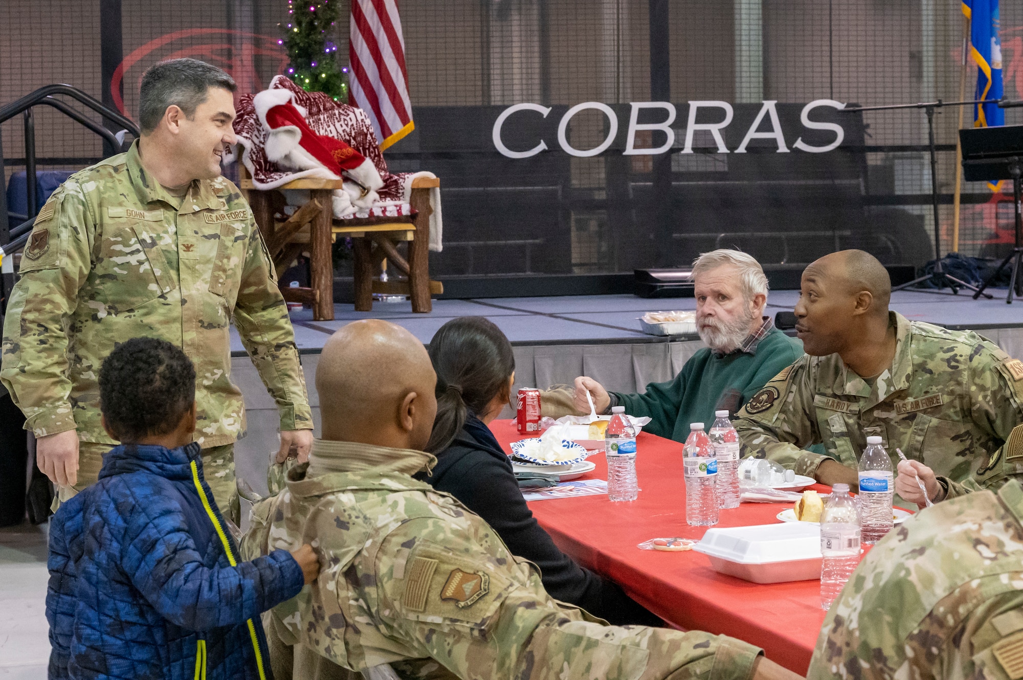 Col. Rusty Gohn, left, 436th Airlift Wing vice commander, speaks with Master Sgt. Perry Hardy, right, 436th Security Forces Squadron first sergeant, and other members of Team Dover during Operation Feed the Troops on Dover Air Force Base, Delaware, Dec. 14, 2022. The 20th annual OFT featured a traditional holiday dinner, desserts, live music and a visit from Santa Claus. (U.S. Air Force photo by Senior Airman Stephani Barge)