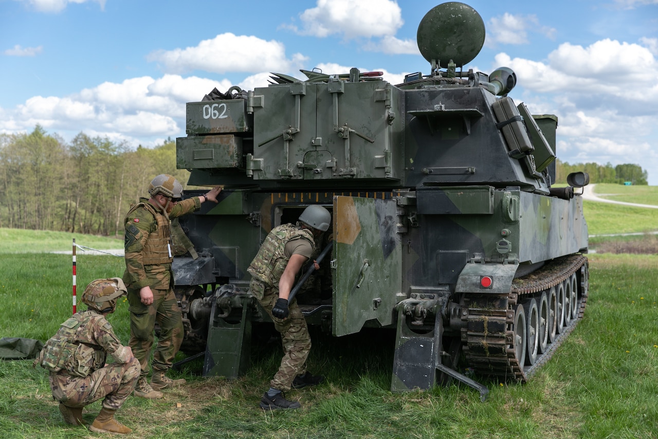 A soldier sits inside a combat vehicle.