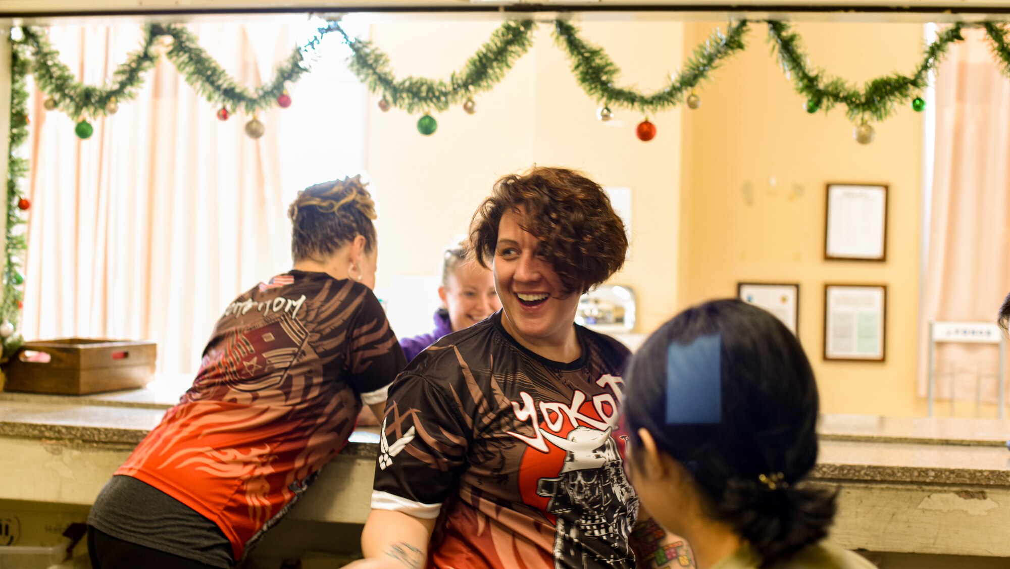 1st Sgt smiles with post office members behind post office counter during holiday season