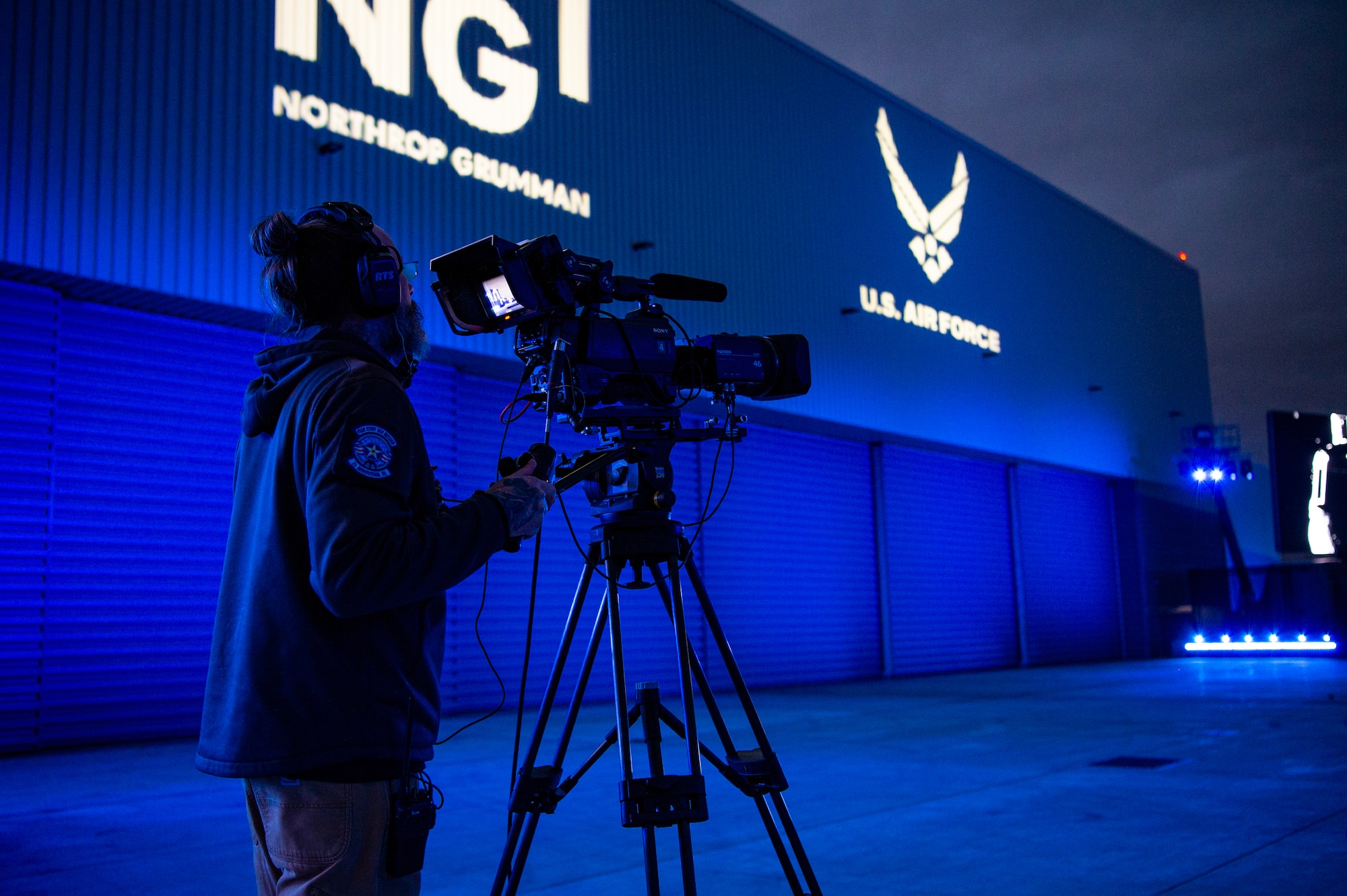 Adam White, 2d Audiovisual Squadron, producer/director, films the B-21 Raider unveiling ceremony at Northrop Grumman’s manufacturing facility on Air Force Plant 42 in Palmdale, California, Dec. 2, 2022.