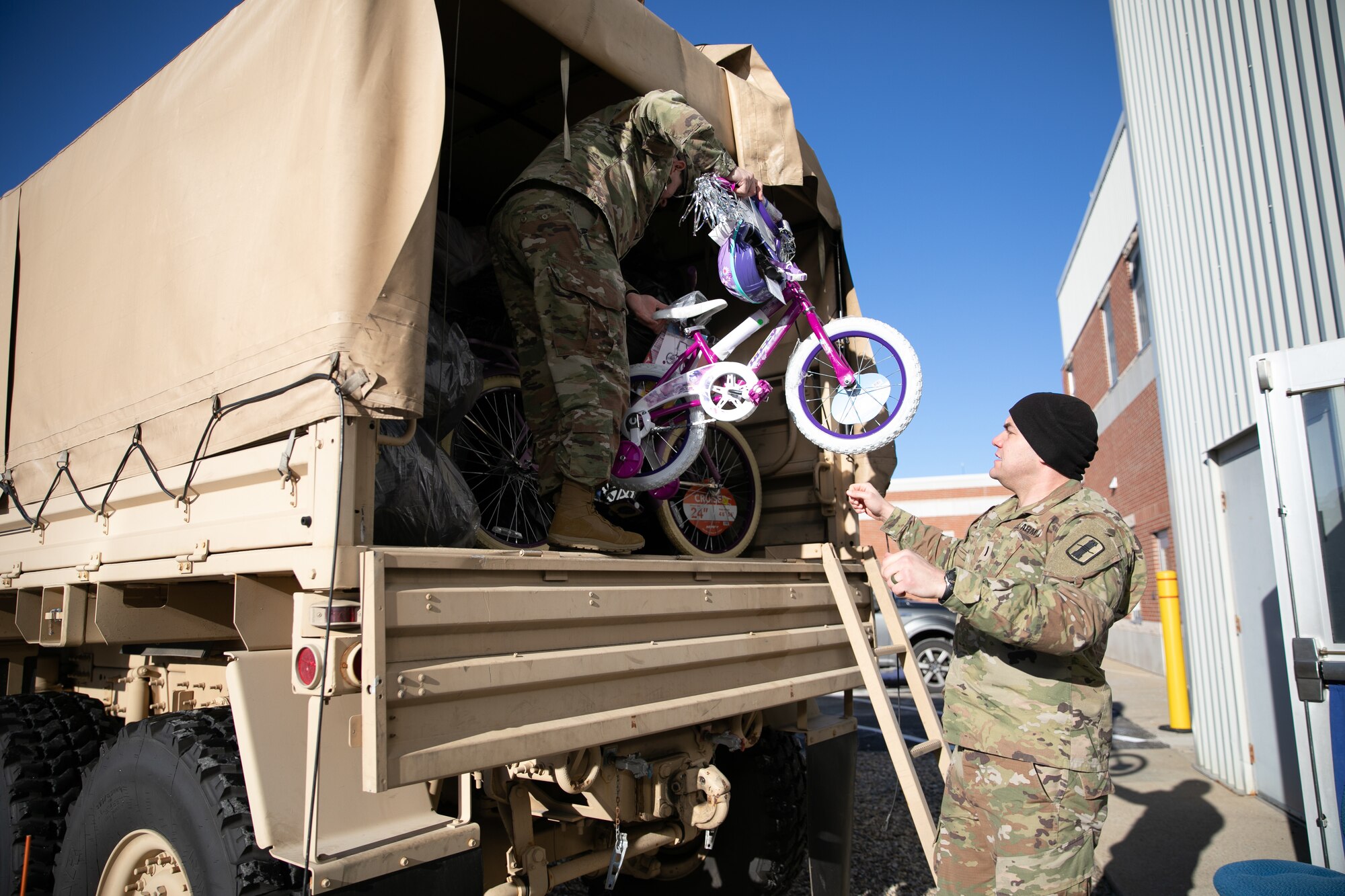1st Lt. Chris Lind with the 197th Field Artillery Brigade (rear detachment) and 1st Sgt. Paul Emond, senior enlisted advisor of NHNG's 744th Forward Support Company, 3rd Battalion, 197th Field Artillery Regiment, load donated bikes into a light medium tactical vehicle for Operation Santa Claus in Concord on Dec. 13, 2022.