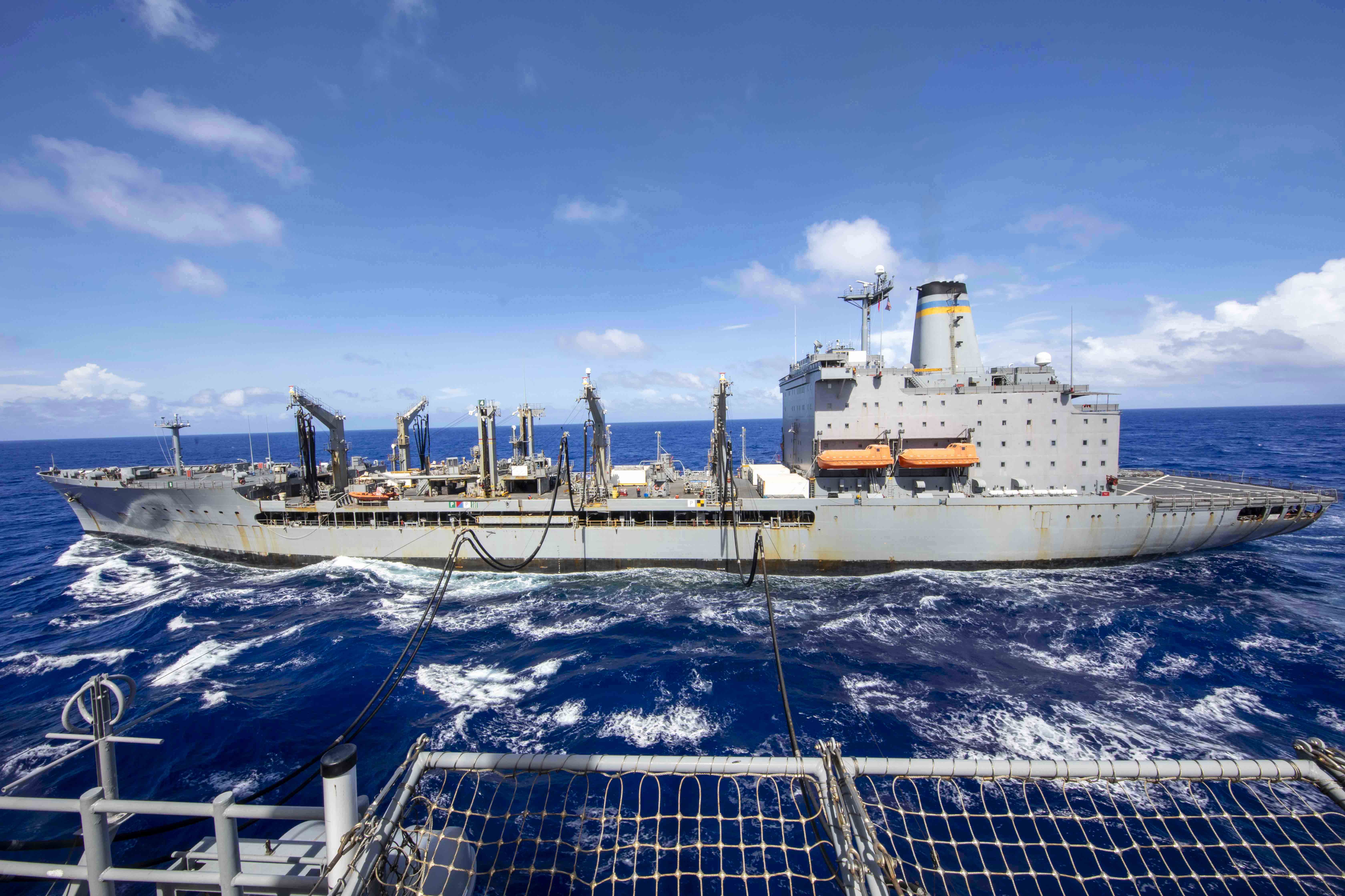 A ship receives fuel from another ship in waters.