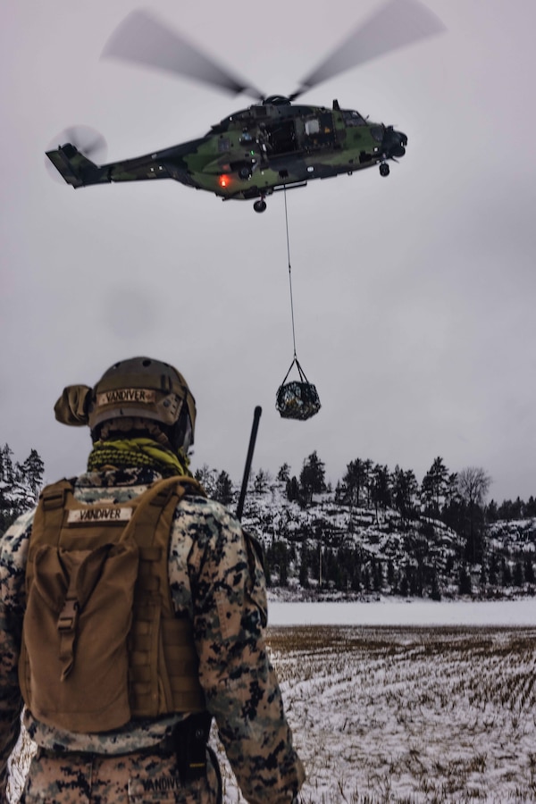 U.S. Marine Corps 1st Lt Anthony Vandiver, logistics officer, with Combat Logistics Battalion 6 (CLB-6), Combat Logistics Regiment 2, 2nd Marine Logistics Group, conducts a helicopter lift with Finnish aircraft NH90 during Freezing Winds 22 in Gumbole, Finland Nov. 30, 2022. Task Force Red Cloud, headquartered by elements of CLB-6, is deployed to Finland in support of Exercises SYD 2022 and Freezing Winds 2022 to enhance U.S. and Finnish select interdependence in the maritime domain; solidify bilateral maritime maneuver within the Finnish littoral environment; and foster strong relationships between U.S. Marine Corps and Finnish Defense Force sustainment units. (U.S. Marine Corps photos by Cpl Jackson Kirkiewicz)