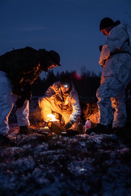 U.S. Marines with 2d Marine Division light a Small Unit Expeditionary (SUE) stove at their campsite during the NATO Cold Weather Instructor Course in Setermoen, Norway, Nov. 24, 2022.