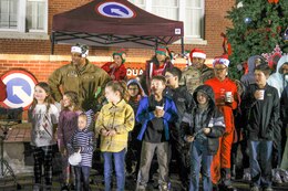 Army children sing with commanding general and command sergeant major