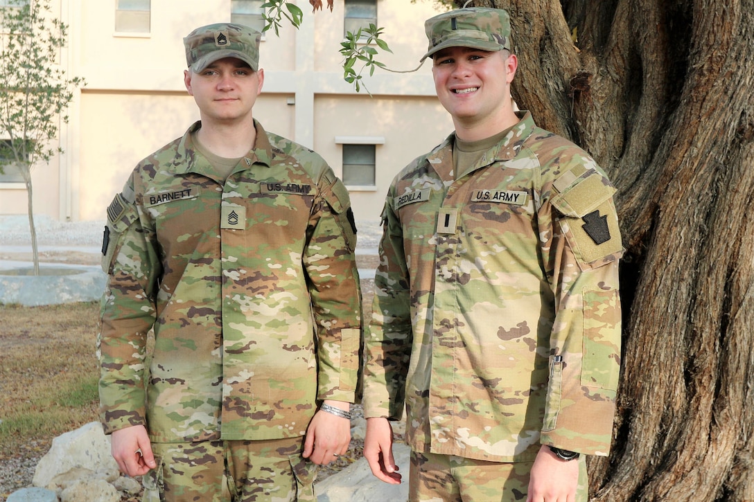 Sgt. 1st Class Zach Barnett, left, an all-source intelligence analyst, and 1st Lt. Ryan Redilla, a contract support officer, both with Headquarters and Headquarters Battalion, 28th Infantry Division, are cousins serving together in Qatar with Task Force Liberty. They had met each other just twice previously and both times while training with their Pennsylvania Army National Guard Units. (U.S. Army National Guard photo by Master Sgt. Doug Roles)