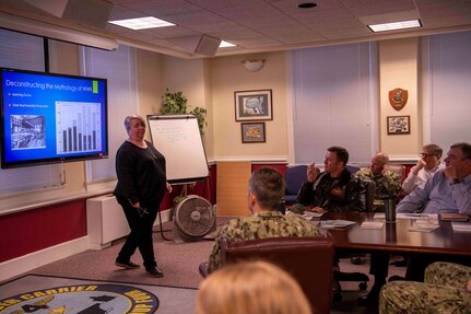 Lori Whitmire, a Naval History and Heritage Command historian, gives a presentation to Commander, Carrier Strike Group (CSG) 4 staff members.