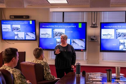 Lori Whitmire, a Naval History and Heritage Command historian, gives a presentation to Commander, Carrier Strike Group (CSG) 4 staff members.