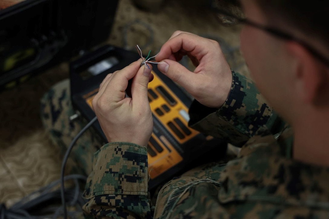 U.S. Marine Corps Lance Cpl. Maxwell Lange, a network administrator with 7th Communication Battalion, III Marine Expeditionary Force Information Group, repairs a cable during a communication exercise on Camp Courtney, Okinawa, Japan, Dec. 8, 2022. The purpose of this exercise is to plan and execute setting up equipment to provide communication resources in preparation for exercise Balikatan. III MIG functions as the vanguard of III MEF, operating in the Indo-Pacific regions information environment, and supports Marine Air Ground Task Force operations with communications, intelligence, and supporting arms liaison capabilities.