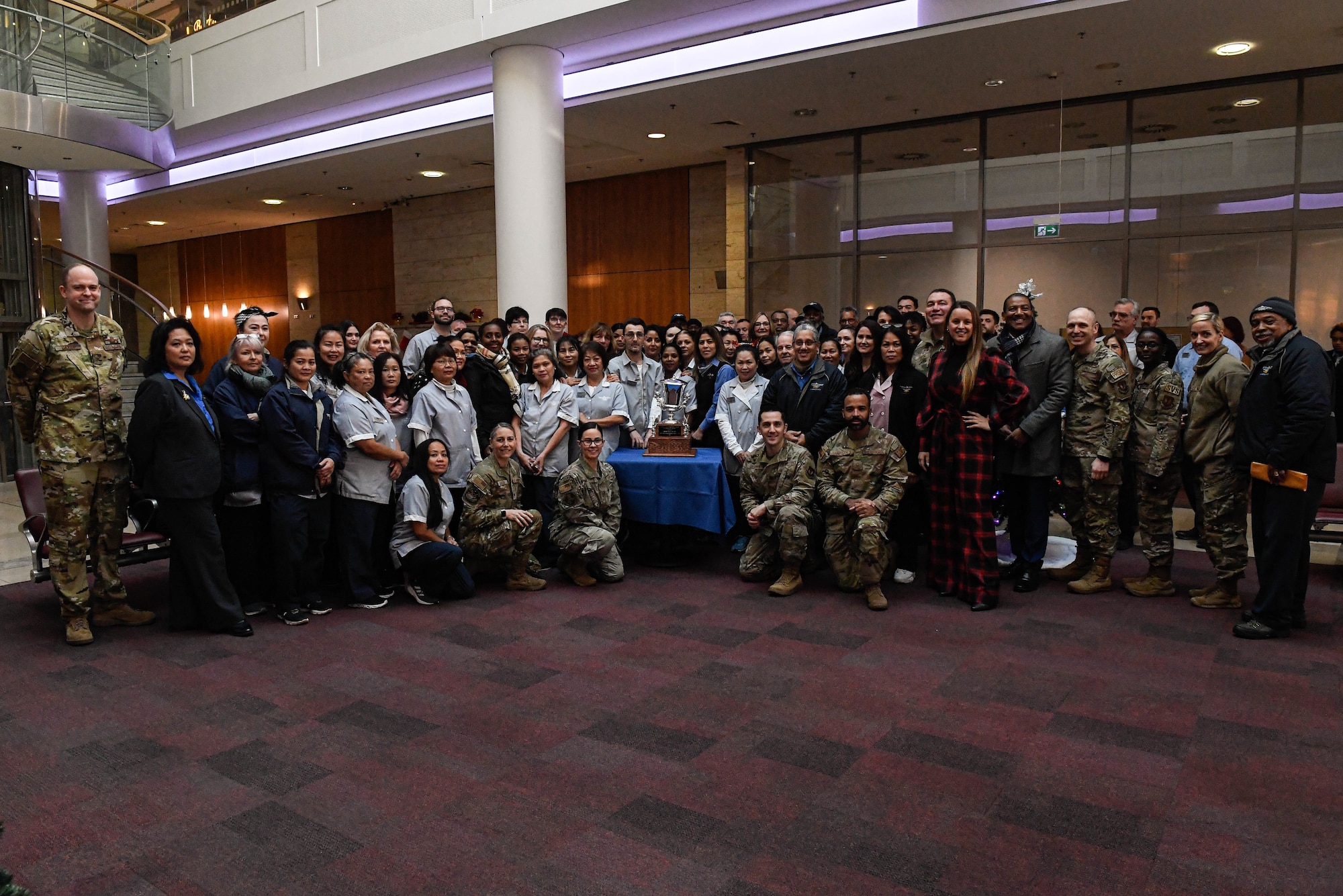Staff from the 786th Force Support Squadron Kaiserslautern Military Community lodging team and other ceremony attendees pose with the 2022 Air Force Innkeeper Award at Ramstein Air Base, Germany, Dec. 12, 2022. This is the second time since 2020 KMC lodging has won the award. (U.S. Air Force photo by Airman 1st Class Kaitlyn Oiler)