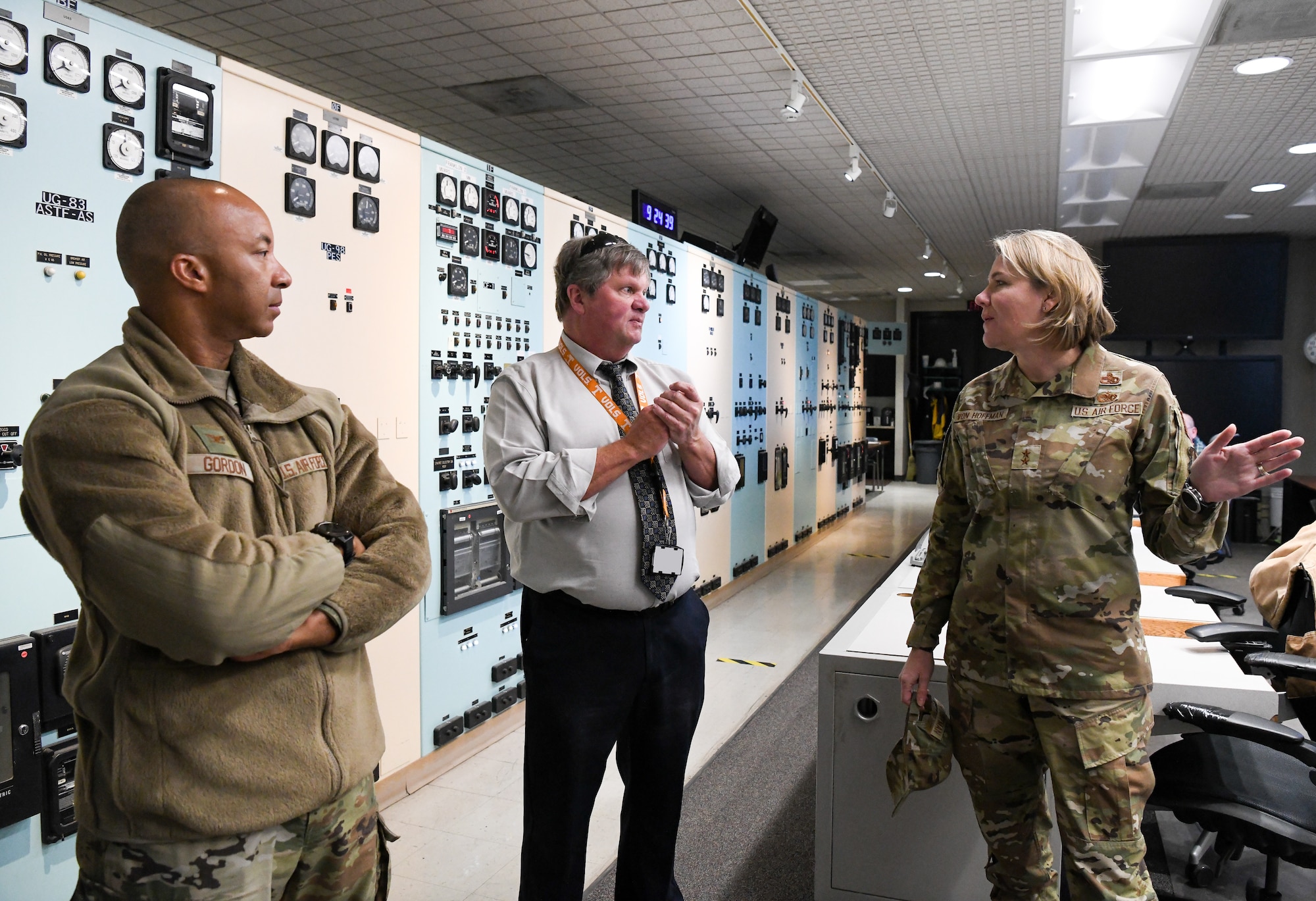 Air Force officer speaking with civilian as another officer listens