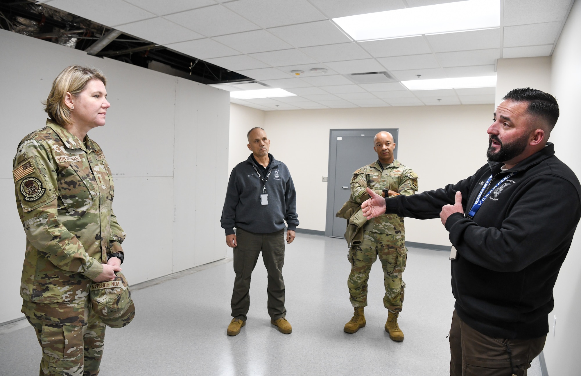 Civilian speaking with Air Force officer as another officer and civilian listen