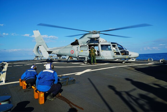 MEDITERRANEAN SEA (Dec. 5, 2022) Boatswain’s Mate 3rd Class Jocelyn Salgado and Boatswain’s Mate 3rd Class Haleem Mitchell prepare to “chock and chain” a French helicopter as Rear Adm. Christophe Cluzel, commander of the French Maritime Force and the French carrier strike group, lands aboard the Arleigh Burke-class guided-missile destroyer USS Arleigh Burke (DDG 51), Dec. 5, 2022. Arleigh Burke is on a scheduled deployment in the U.S. Naval Forces Europe area of operations, employed by U.S. Sixth Fleet to defend U.S., allied and partner interests. (U.S. Navy photo by Ensign Benjamin Cusimano)