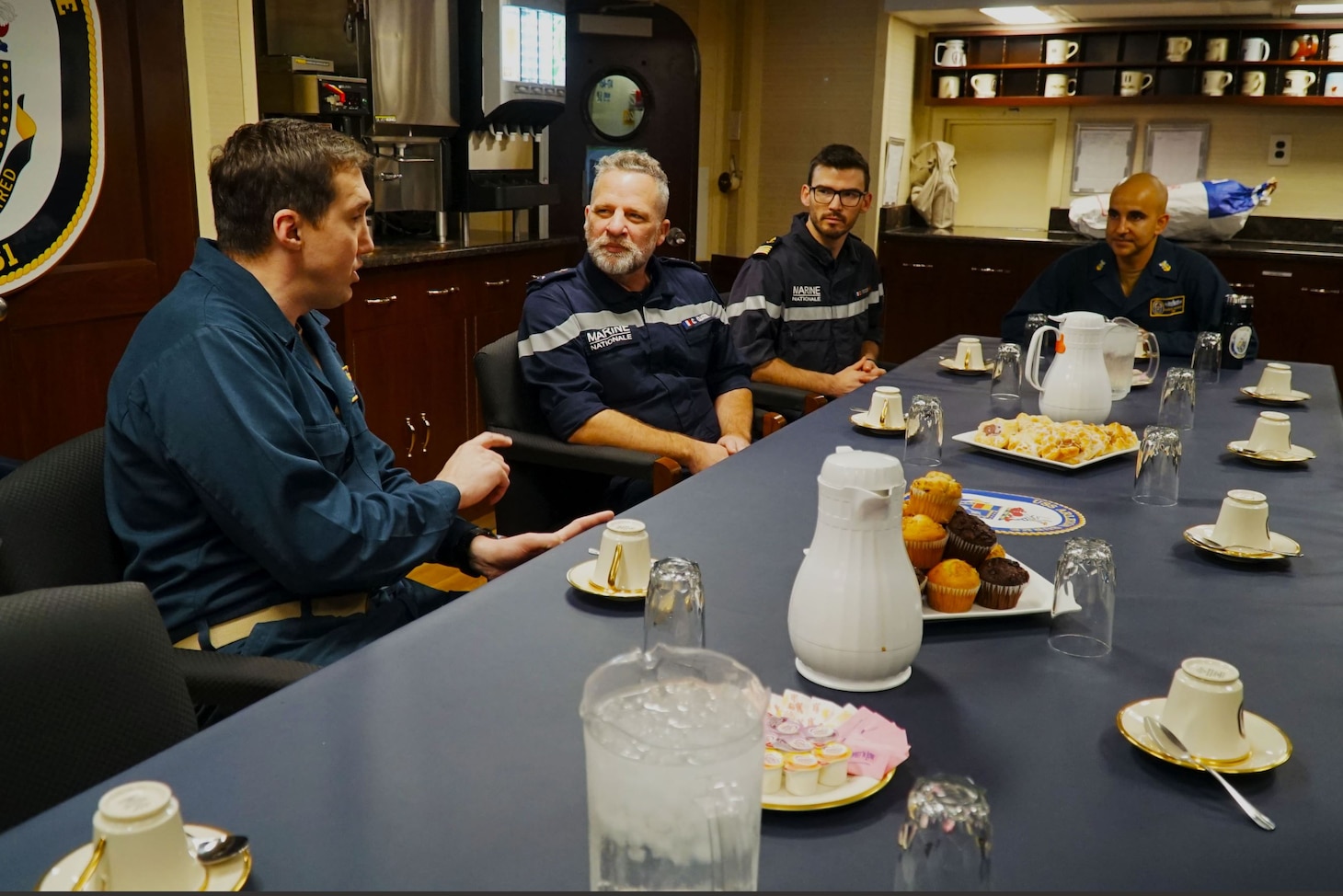 MEDITERRANEAN SEA (Dec. 5, 2022) Cmdr. Peter Flynn, commanding officer of USS Arleigh Burke, left, hosts Rear Adm. Christophe Cluzel, commander of the French Maritime Force and the French carrier strike group, in the Wardroom during a tour of the ship, Dec. 5, 2022. Arleigh Burke is on a scheduled deployment in the U.S. Naval Forces Europe area of operations, employed by U.S. Sixth Fleet to defend U.S., allied and partner interests. (U.S. Navy photo by Ensign Benjamin Cusimano)