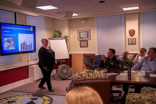 Lori Whitmire, a Naval History and Heritage Command historian, gives a presentation to Commander, Carrier Strike Group (CSG) 4 staff members.