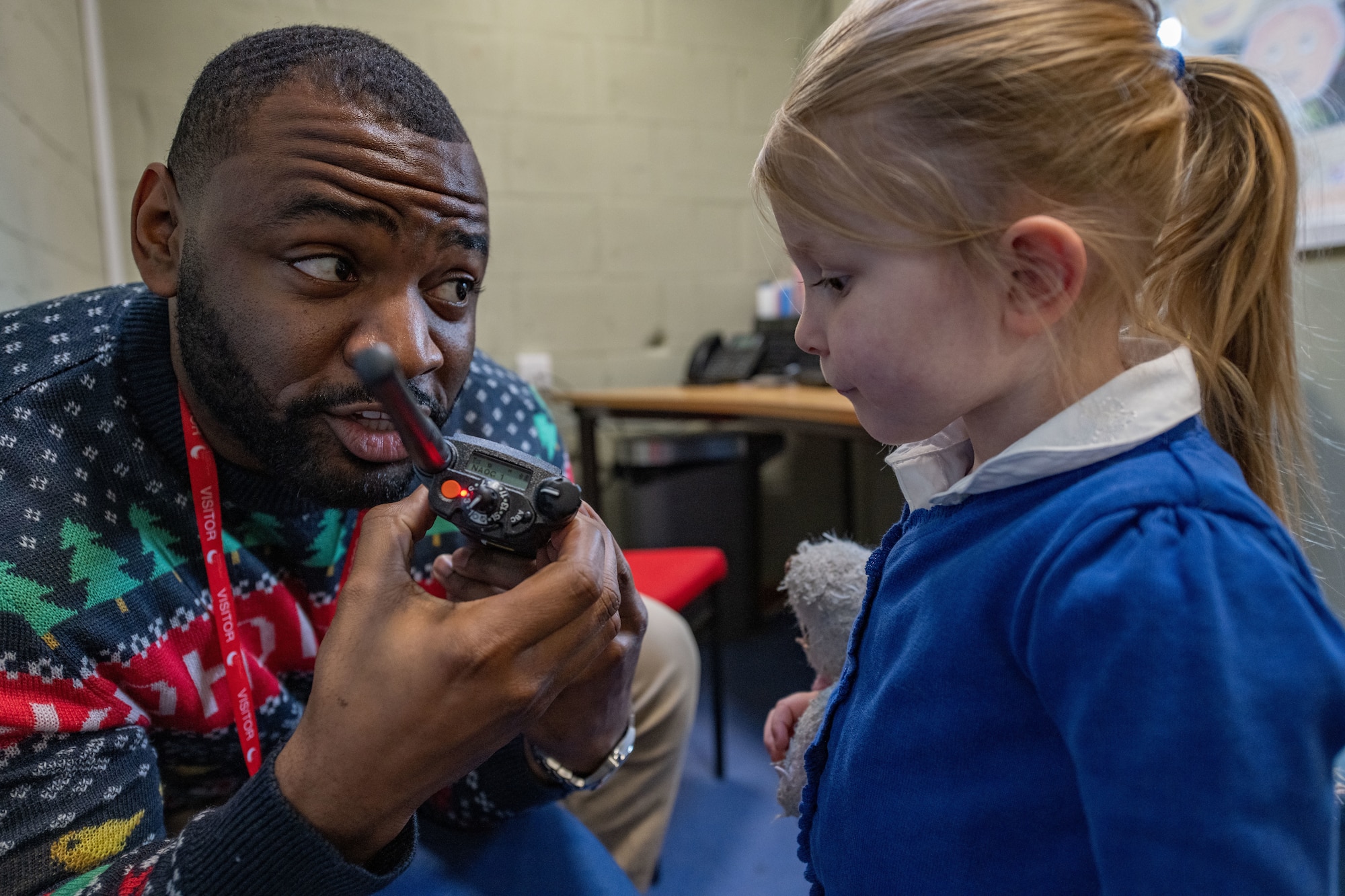 Staff Sgt. Matthew Mason, 100th Communications Squadron radio frequency transmissions NCO in charge, helps a Beck Row Primary Academy student communicate over land mobile radios