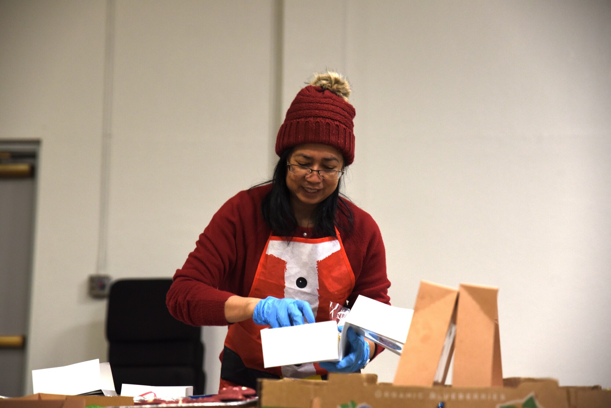 A Team McChord volunteer organizes cookies into a box for Operation Cookie Drop at Joint Base Lewis-McChord, Washington, Dec. 14, 2022. The goal of Operation Cookie Drop is to spread holiday cheer by giving single Airmen a dozen home-baked cookies provided by the McChord community. (U.S. Air Force photo by Airmen Kylee Tyus)