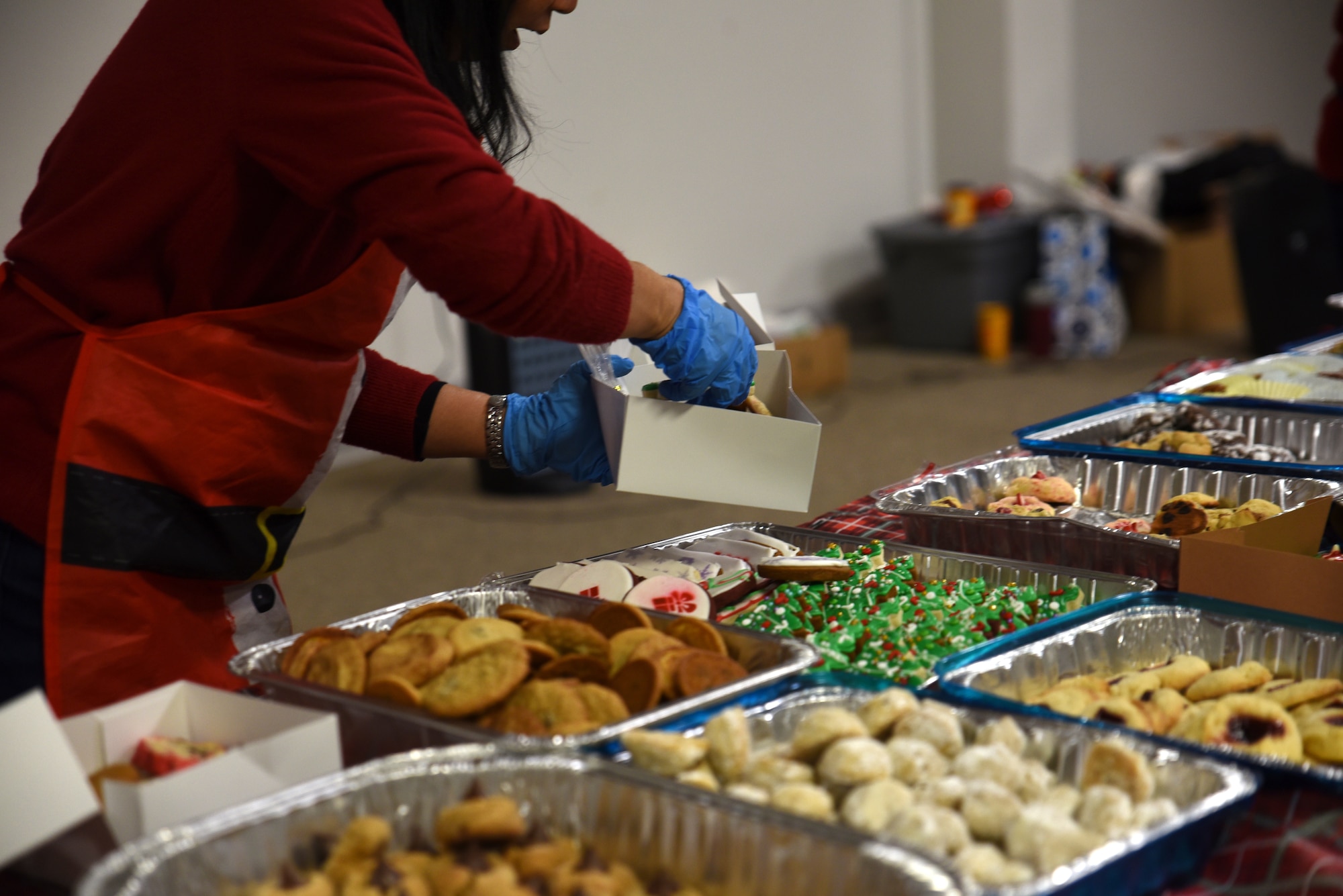 A Team McChord volunteer packages cookies into a box during Operation Cookie Drop at Joint Base Lewis-McChord, Washington, Dec. 14, 2022. The goal of Operation Cookie Drop is to spread holiday cheer by giving single Airmen a dozen home-baked cookies provided by the McChord community. (U.S. Air force photo by Airmen Kylee Tyus)