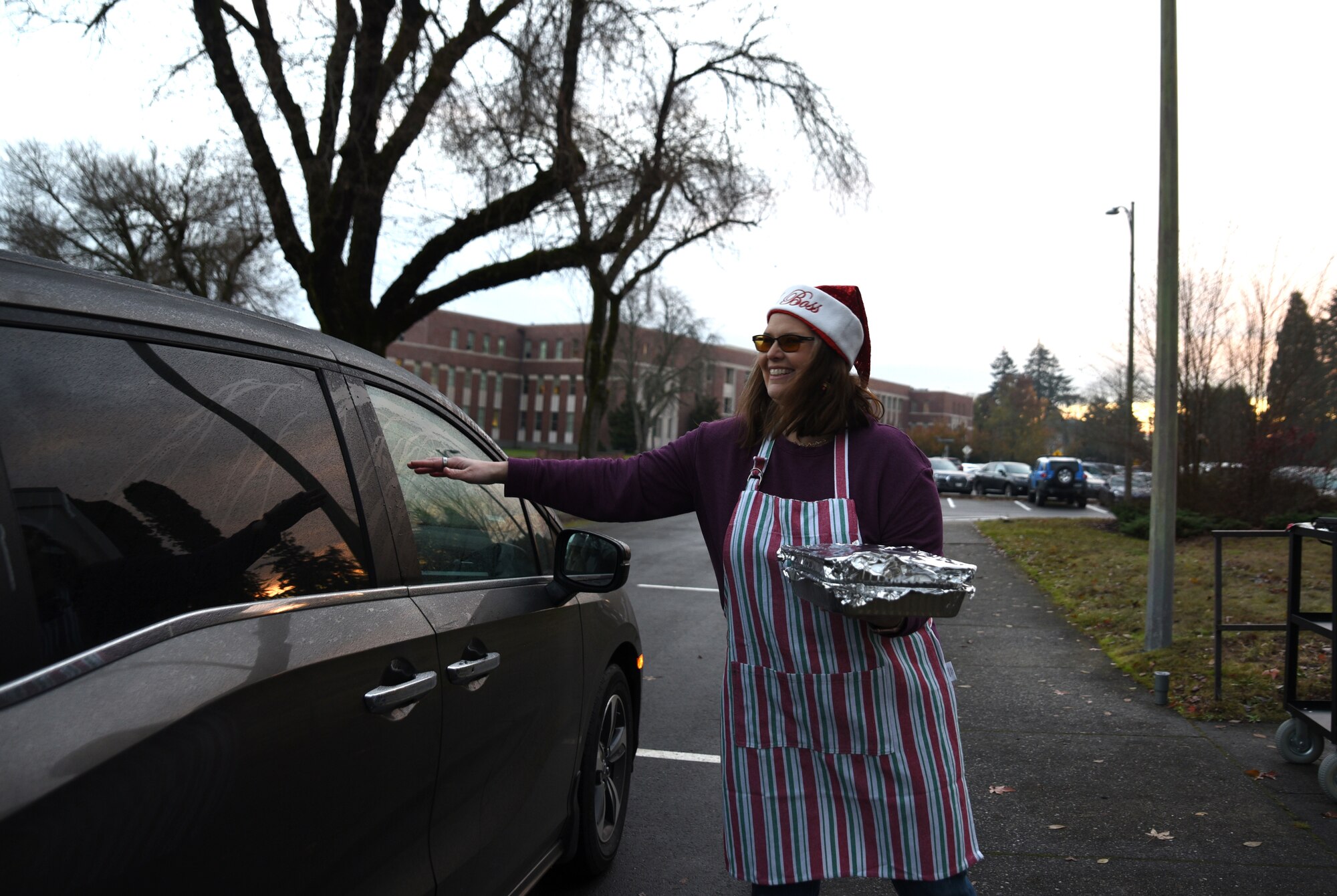 A volunteer receives a batch of cookies from a donor during Operation Cookie Drop at Joint Base Lewis-McChord, Washington, Dec. 14, 2022. The goal of Operation Cookie Drop is to spread holiday cheer by giving single Airmen a dozen home-baked cookies provided by the McChord community. (U.S. Air Force photo by Airman Kylee Tyus)