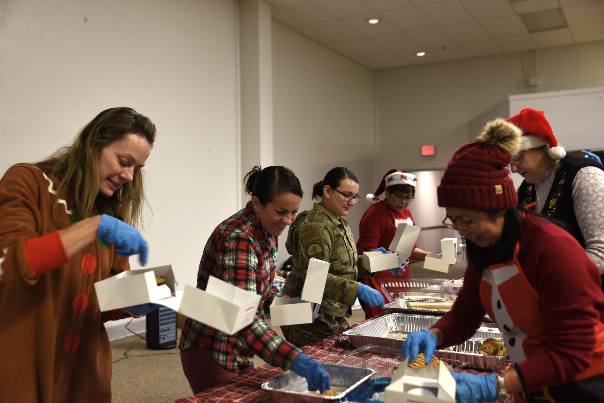 Team McChord volunteers box homemade cookies for Operation Cookie Drop at Joint Base Lewis-McChord, Washington, Dec. 14, 2022. The goal of Operation Cookie Drop is to spread holiday cheer by giving single Airmen a dozen home-baked cookies provided by the Team McChord community. (U.S. Air Force photo by Airmen Kylee Tyus)