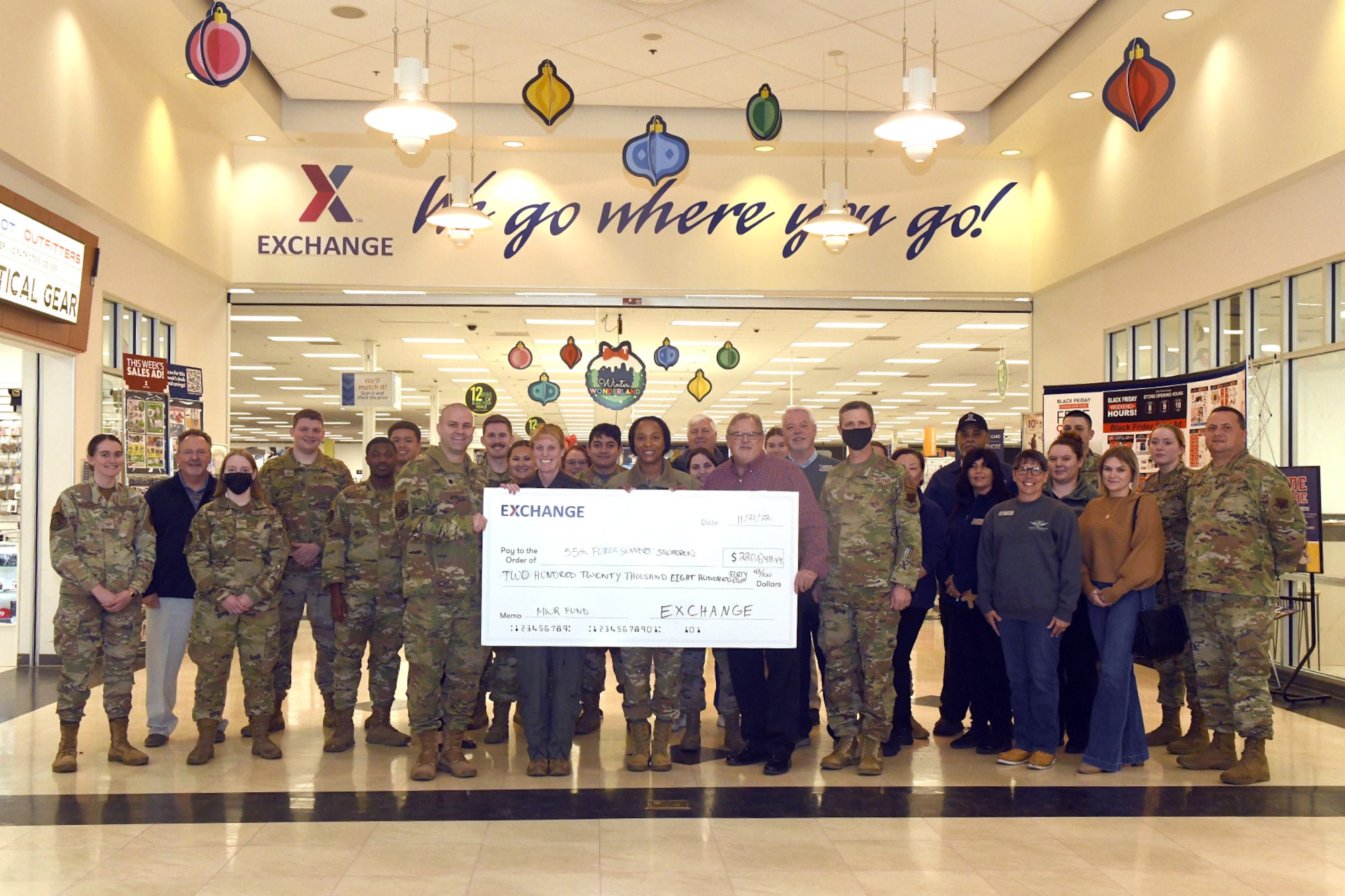 A group of people pose for a photo while holding an oversized check
