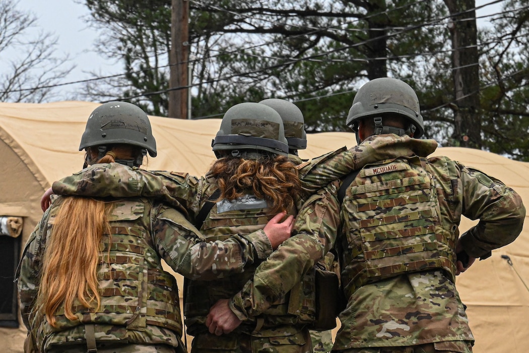 Two Airmen carry another Airman.