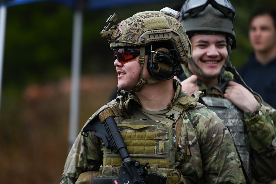An Airman stands in a group with his weapon.